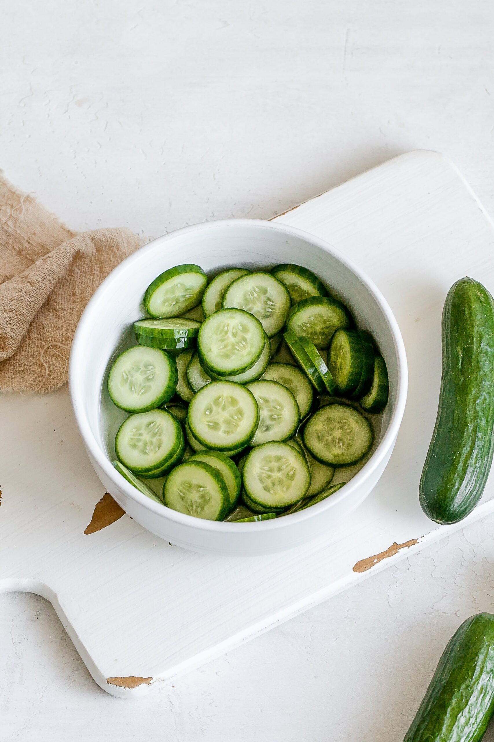 sliced cucumbers in bowl with vinegar. 