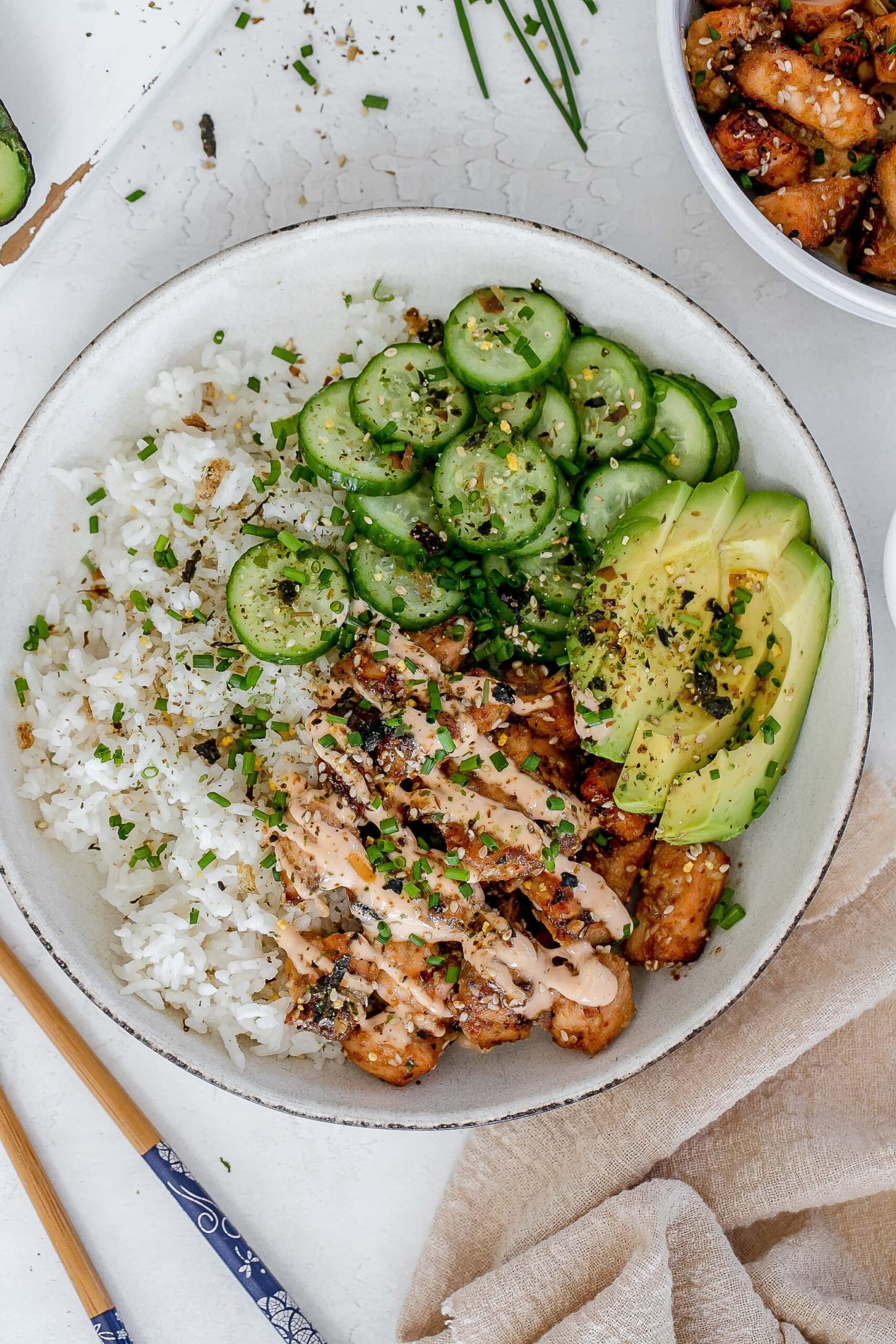 spicy salmon bowl with rice and pickled cucumbers.