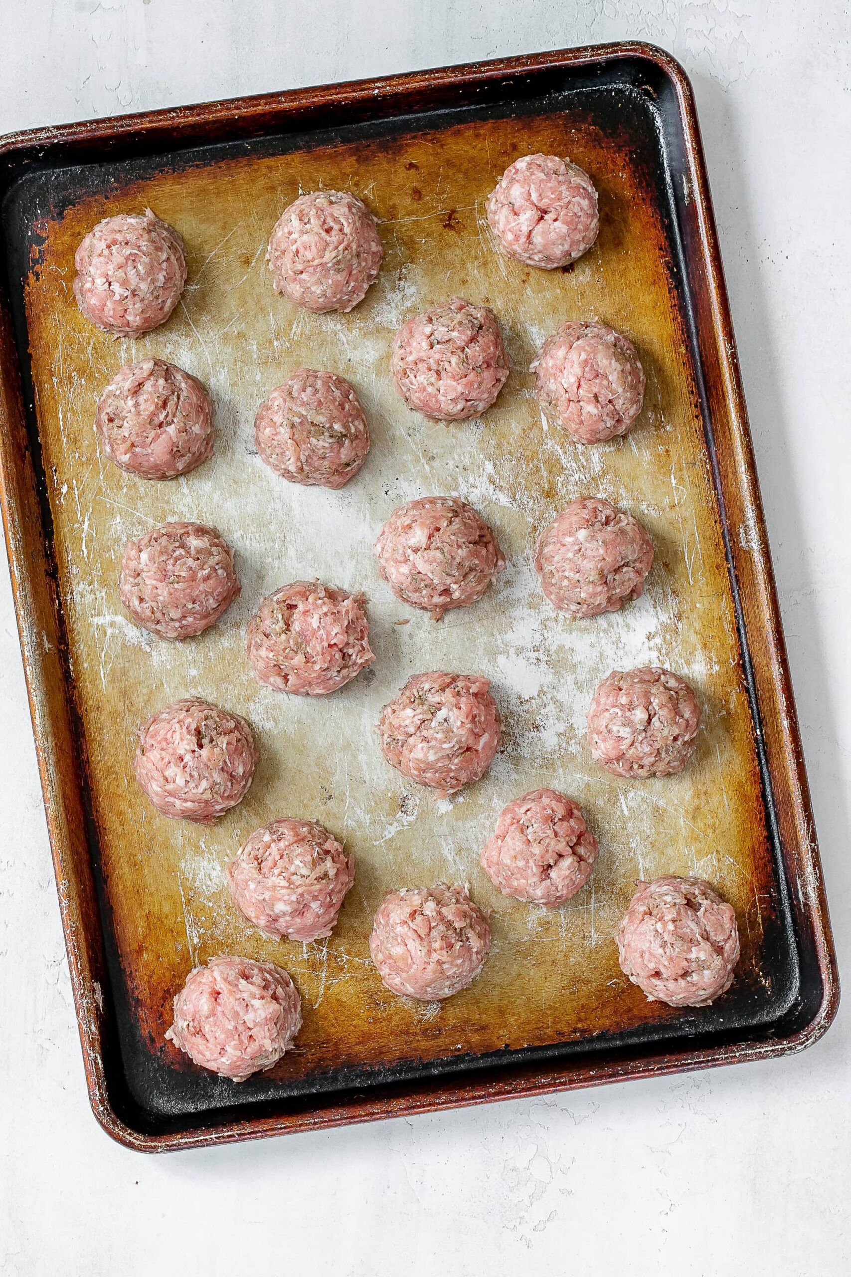 uncooked breakfast pork meatballs on baking sheet.