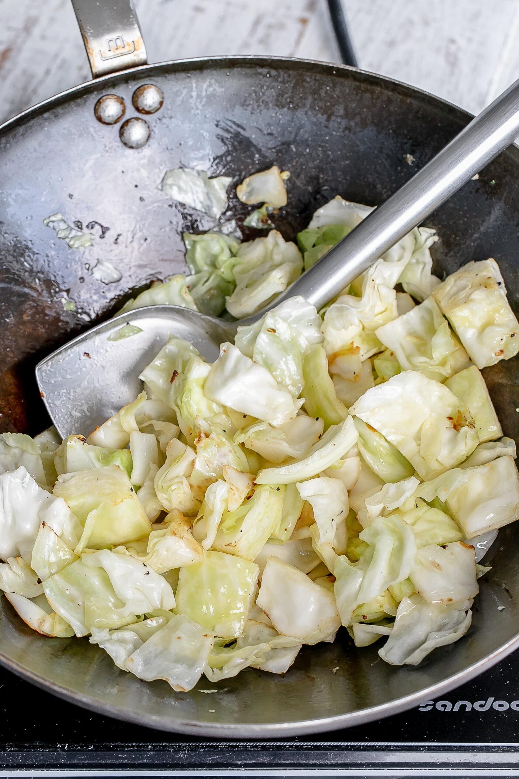cabbage and onion in a wok.