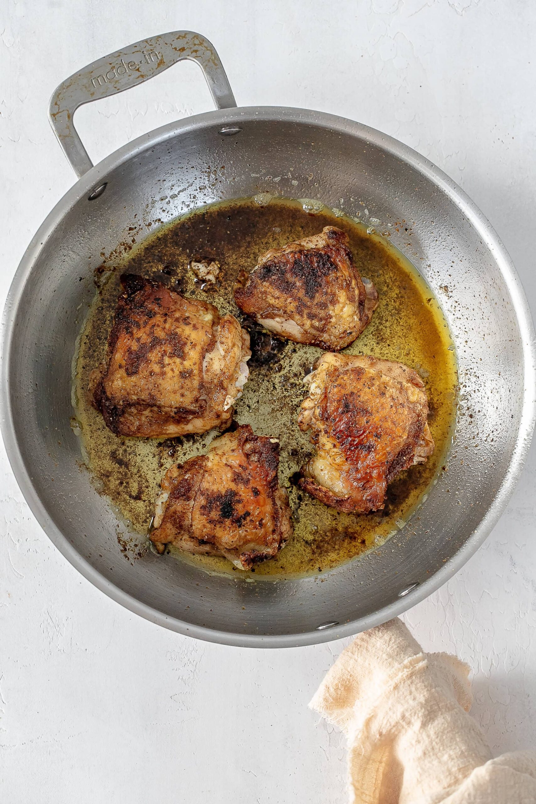 cooked chicken thighs in skillet.