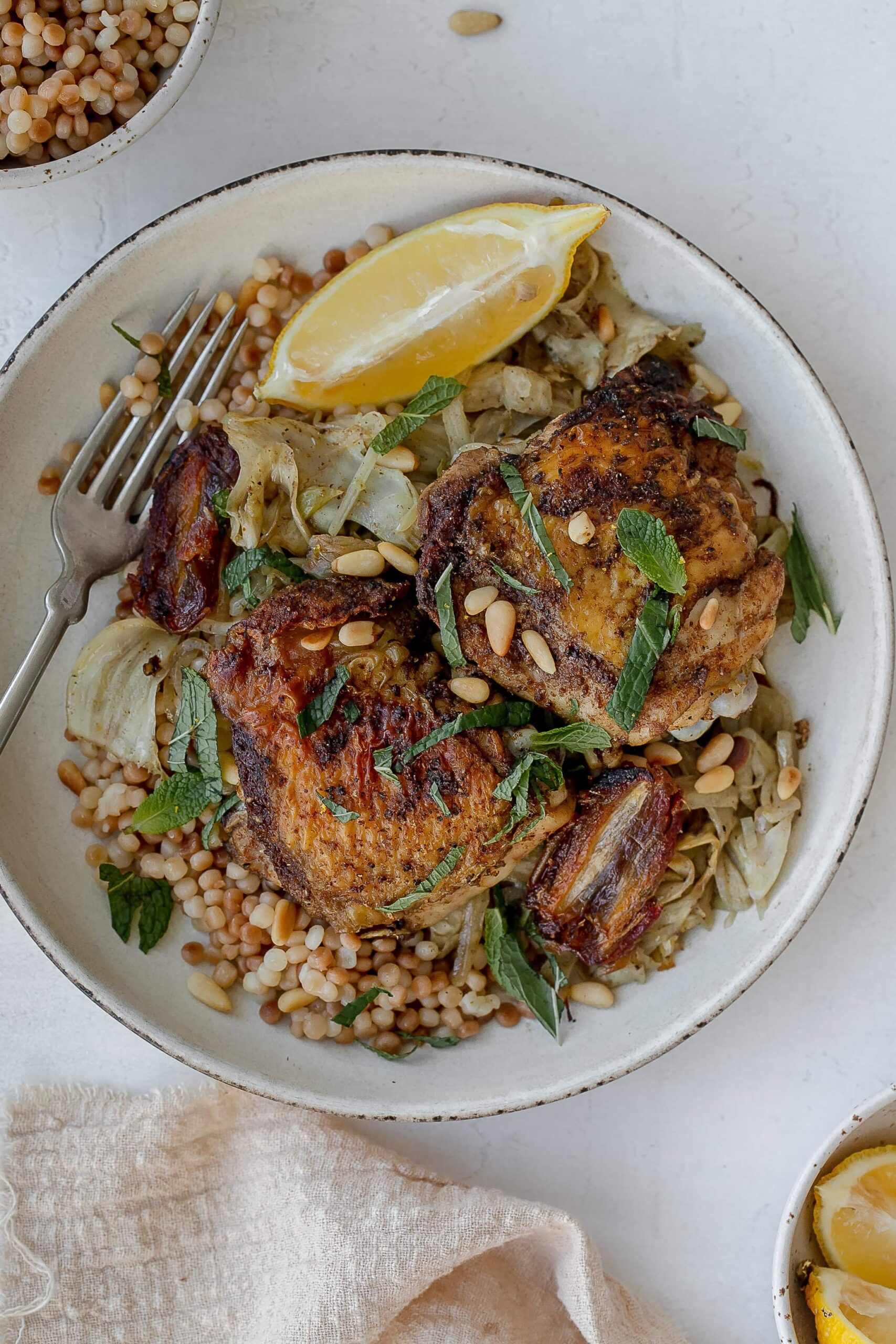 chicken thighs with fennel on a plate with couscous. 