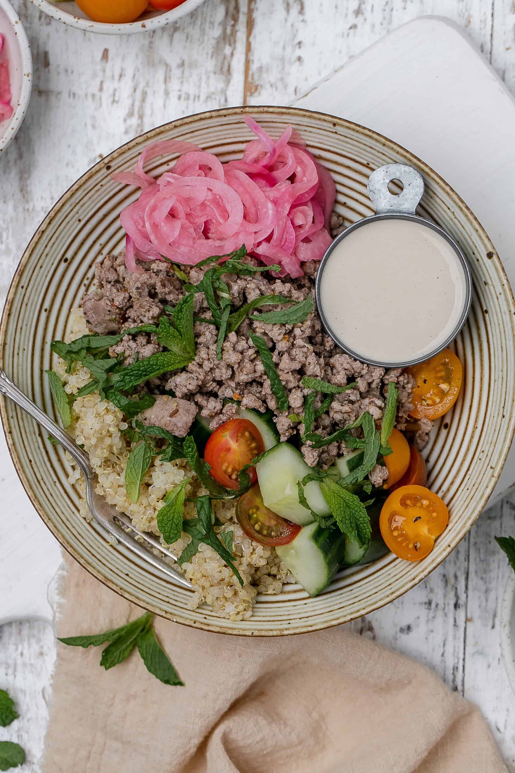 ground lamb bowl with tahini sauce on the side. 
