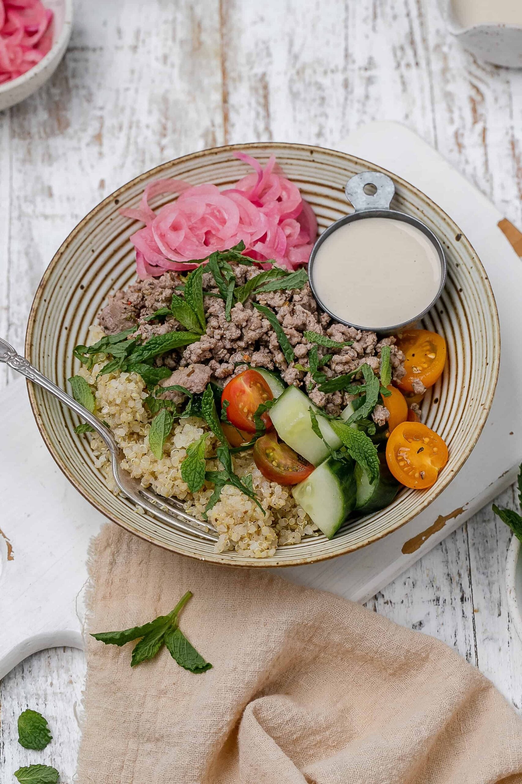 ground lamb bowl with tahini sauce on the side. 