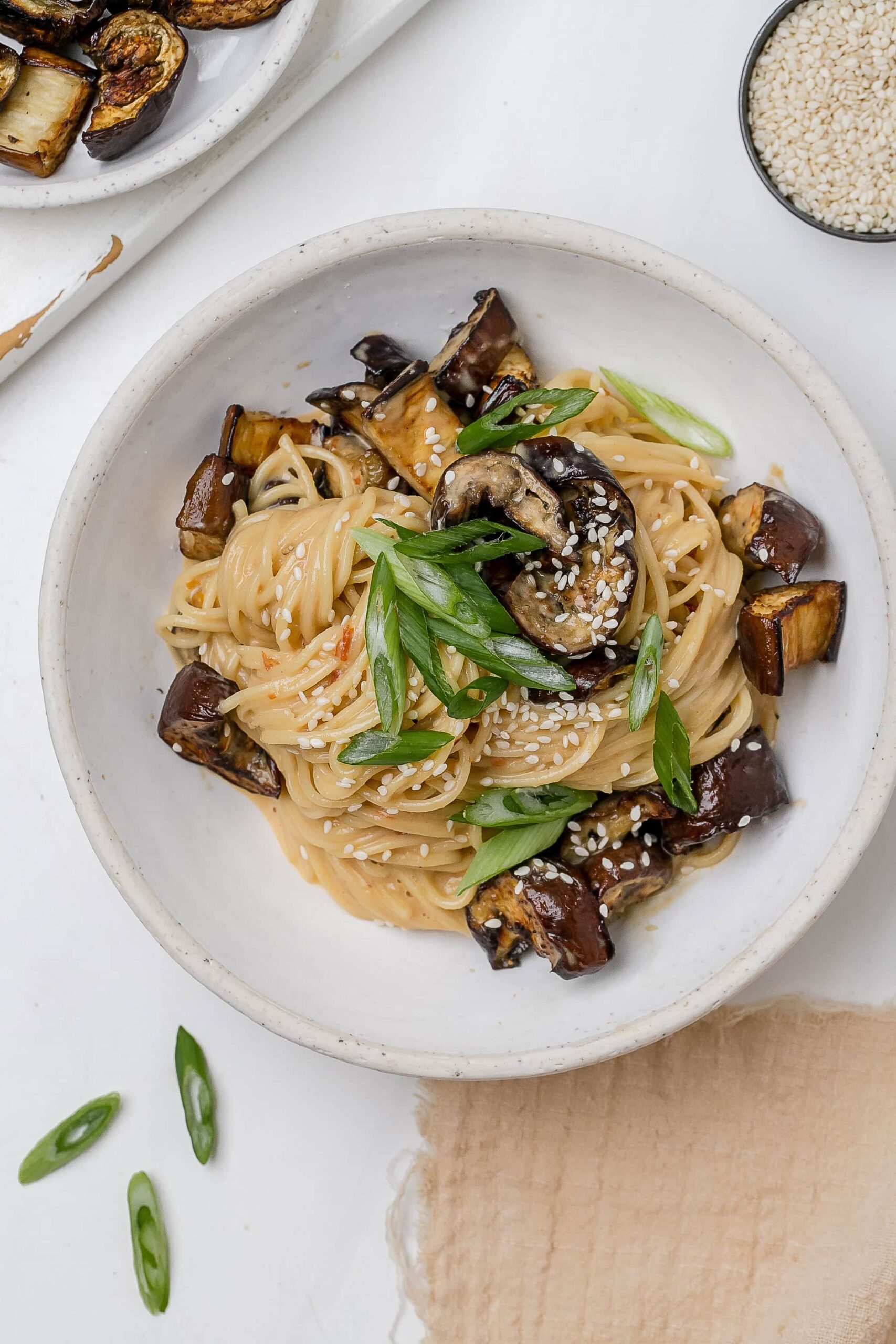noodles with eggplant and miso tahini butter sauce in a bowl.