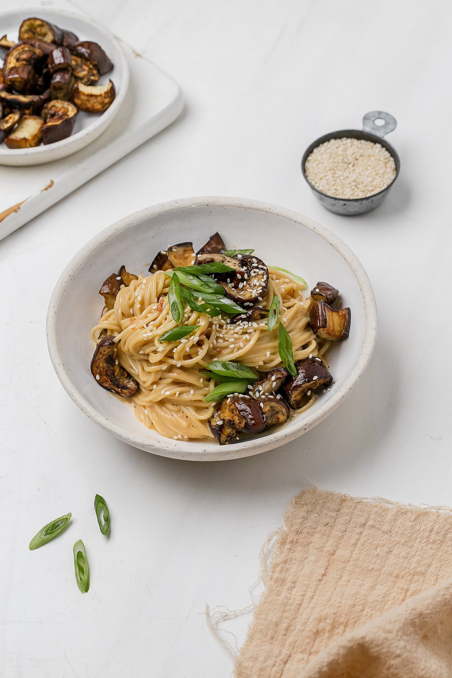 noodles with eggplant and miso tahini butter sauce in a bowl.