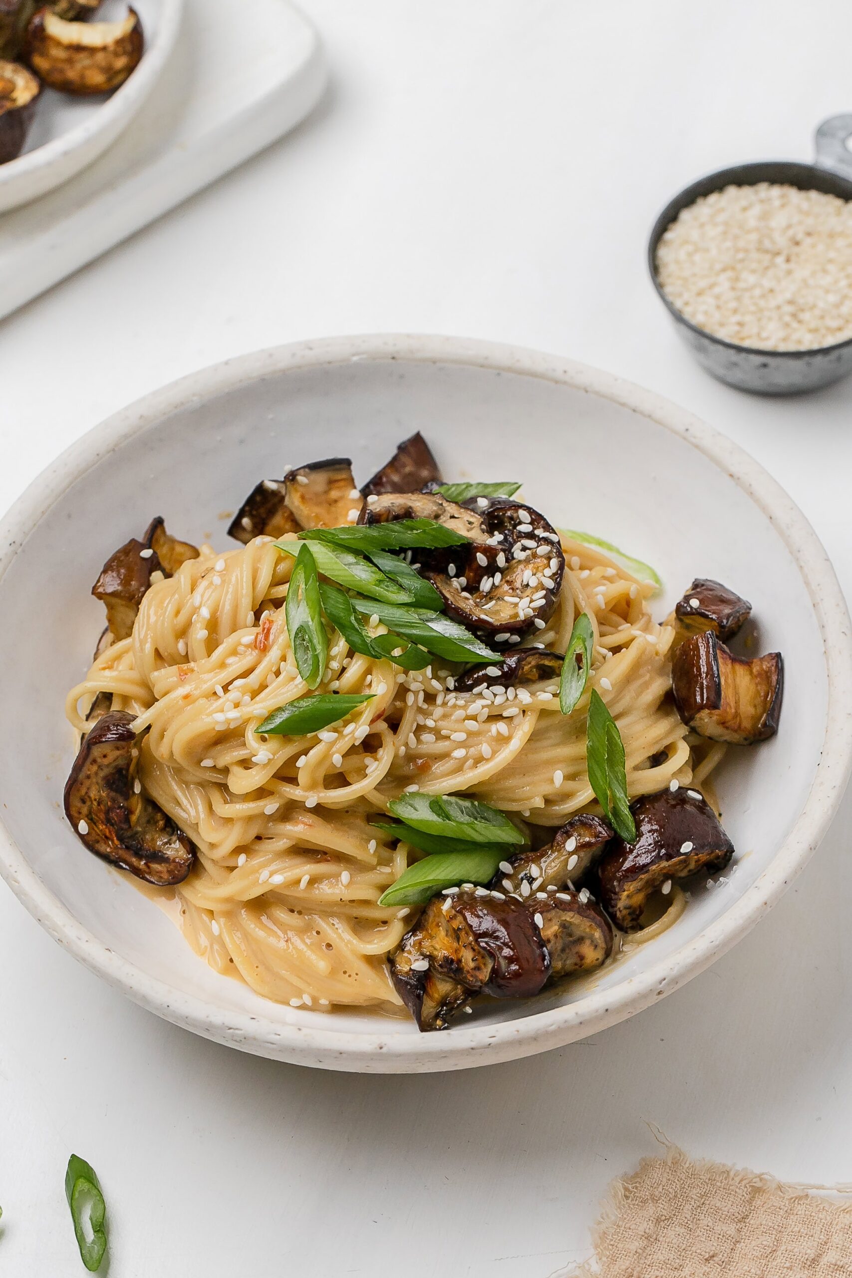 noodles with eggplant and miso tahini butter sauce in a bowl.