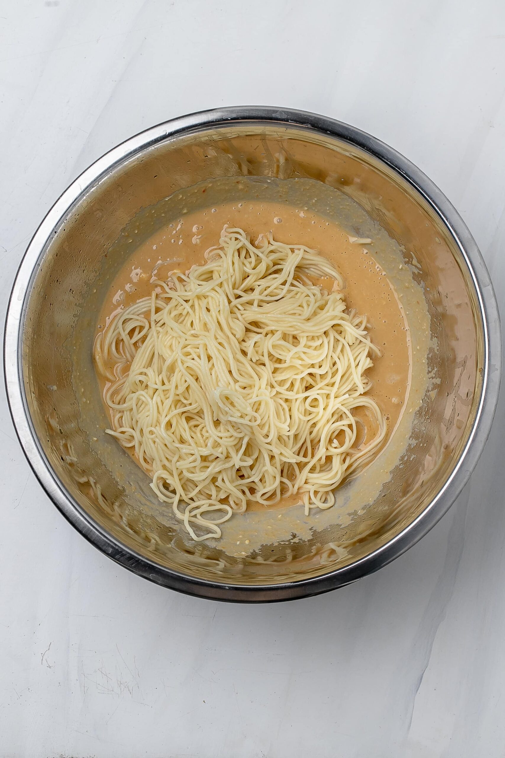 noodles added to sauce in large bowl.