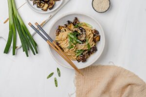 noodles with eggplant and miso tahini butter sauce in a bowl.