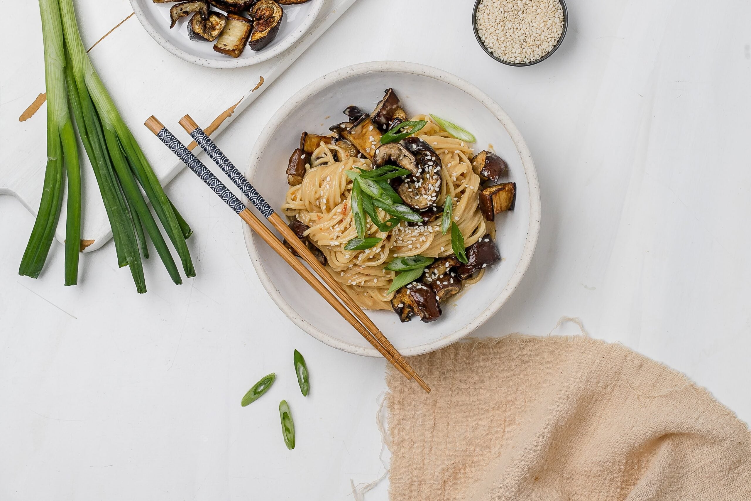 noodles with eggplant and miso tahini butter sauce in a bowl.