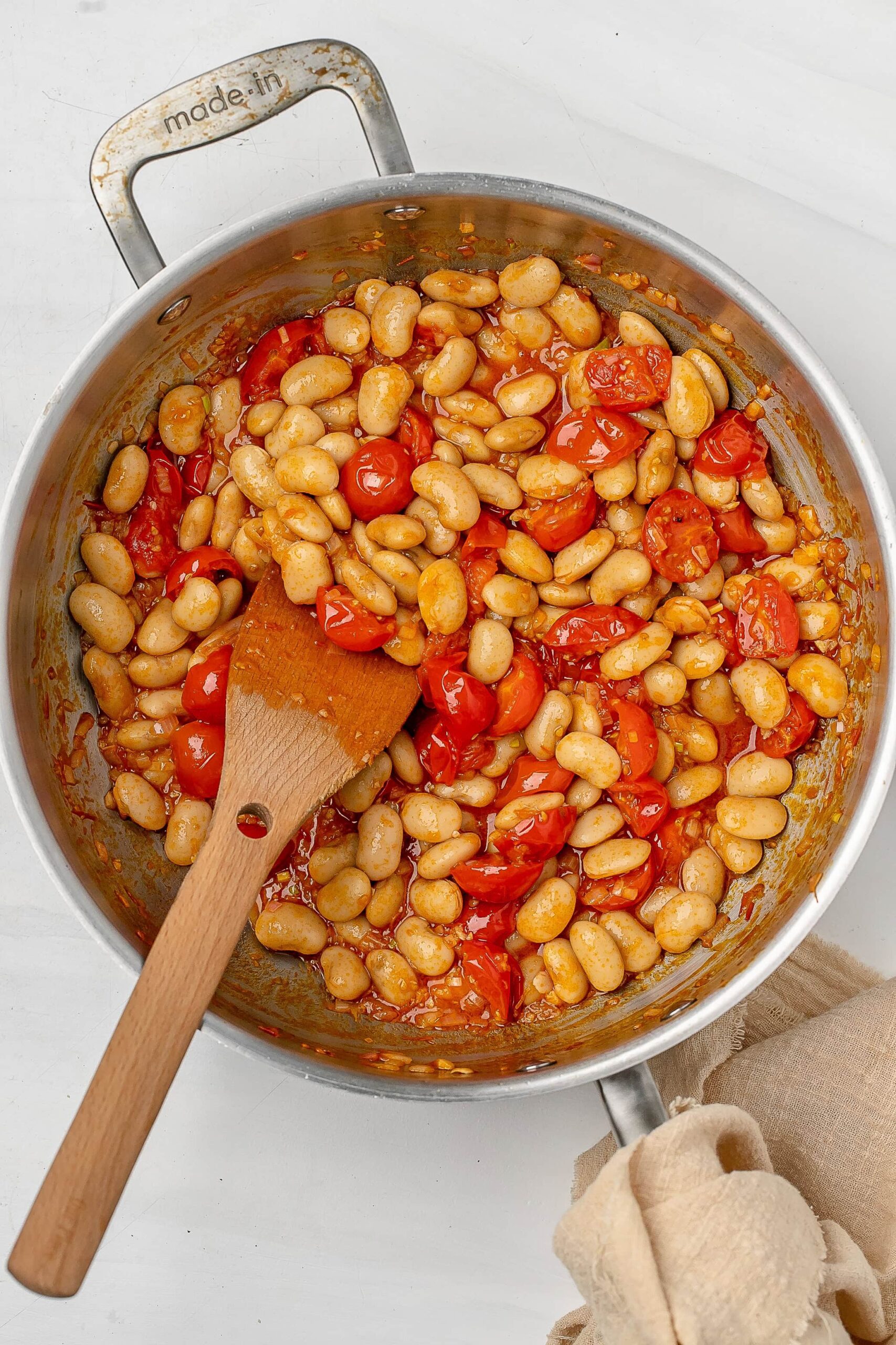 cherry tomatoes with harissa and beans in a pot.