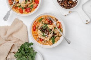 harissa cod poached in coconut milk in a bowl with orzo.