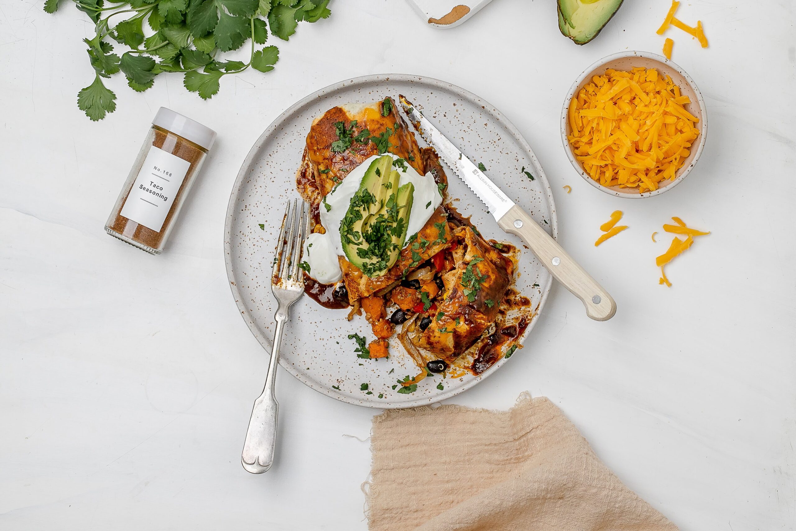 quinoa and veggie enchiladas on a plate with toppings.