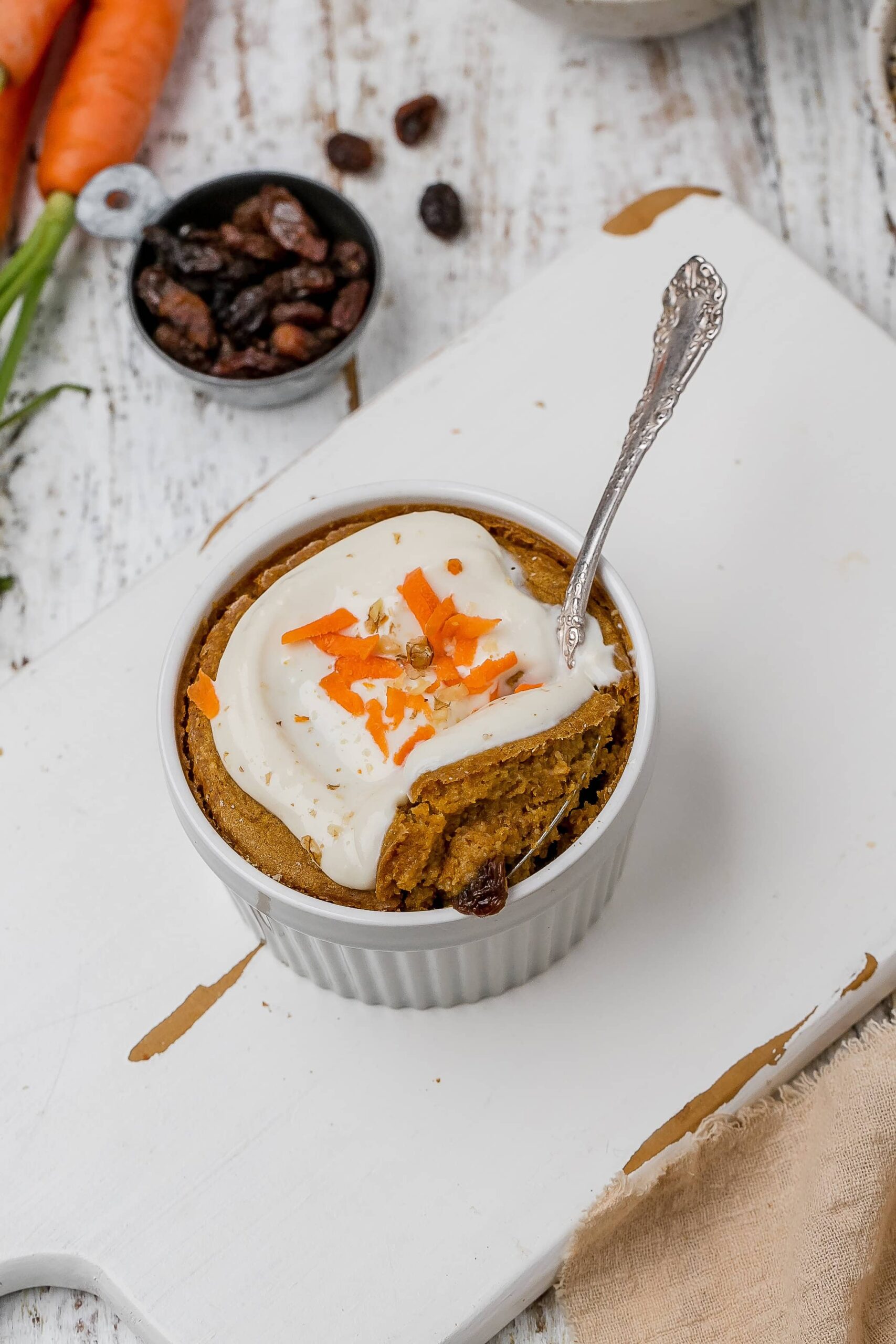 carrot cake baked oats with icing on top in ramekins.