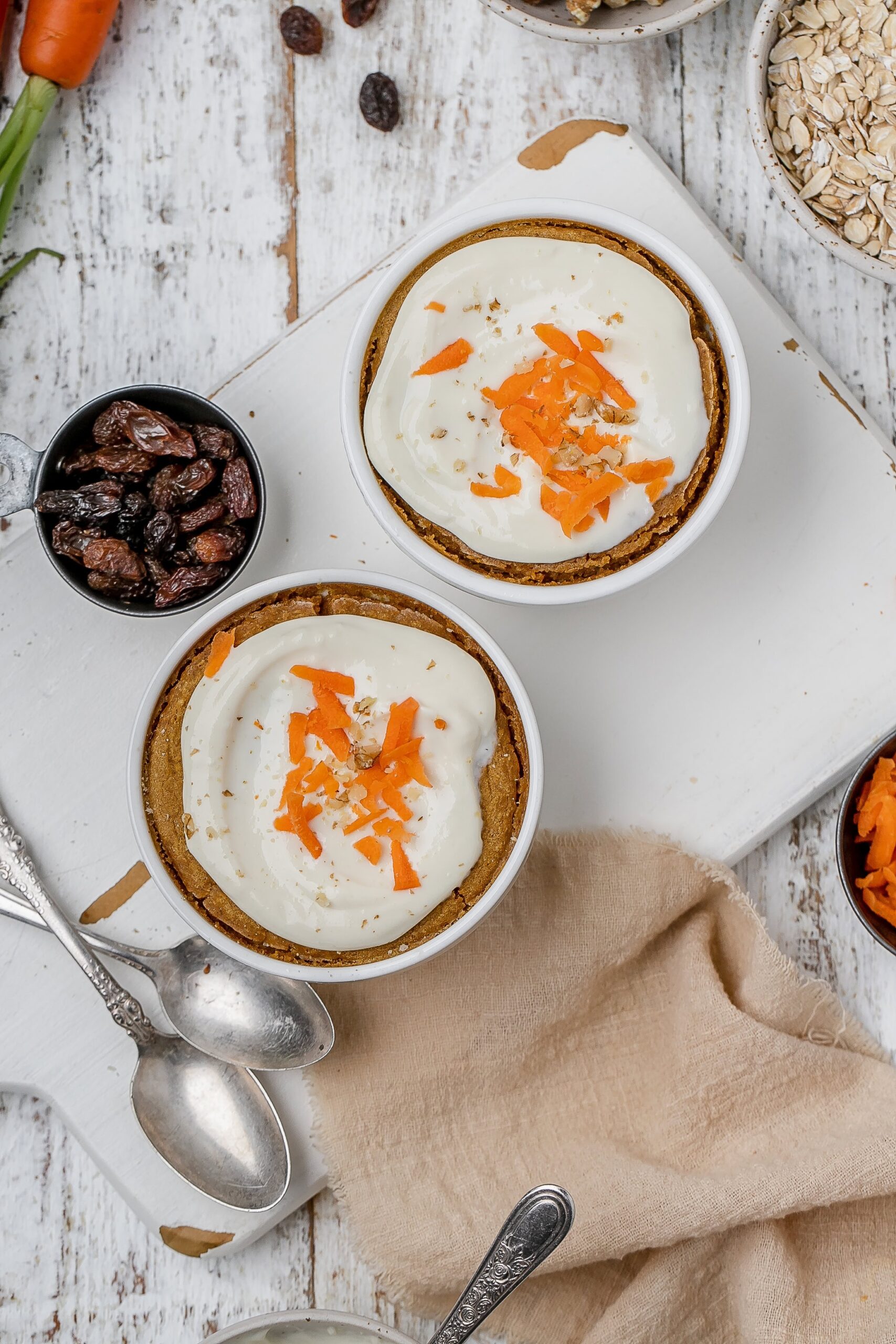 carrot cake baked oats with icing on top in ramekins.