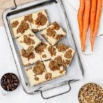 carrot cake cookie bars with cheesecake swirl on a baking sheet.