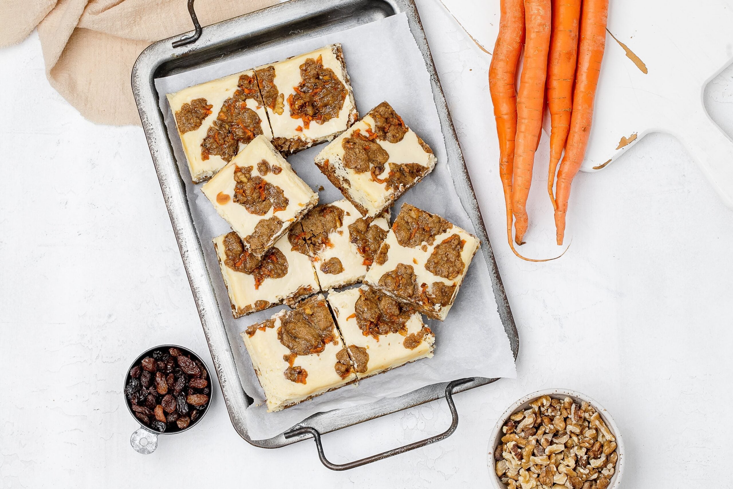 carrot cake cookie bars with cheesecake swirl on a baking sheet.