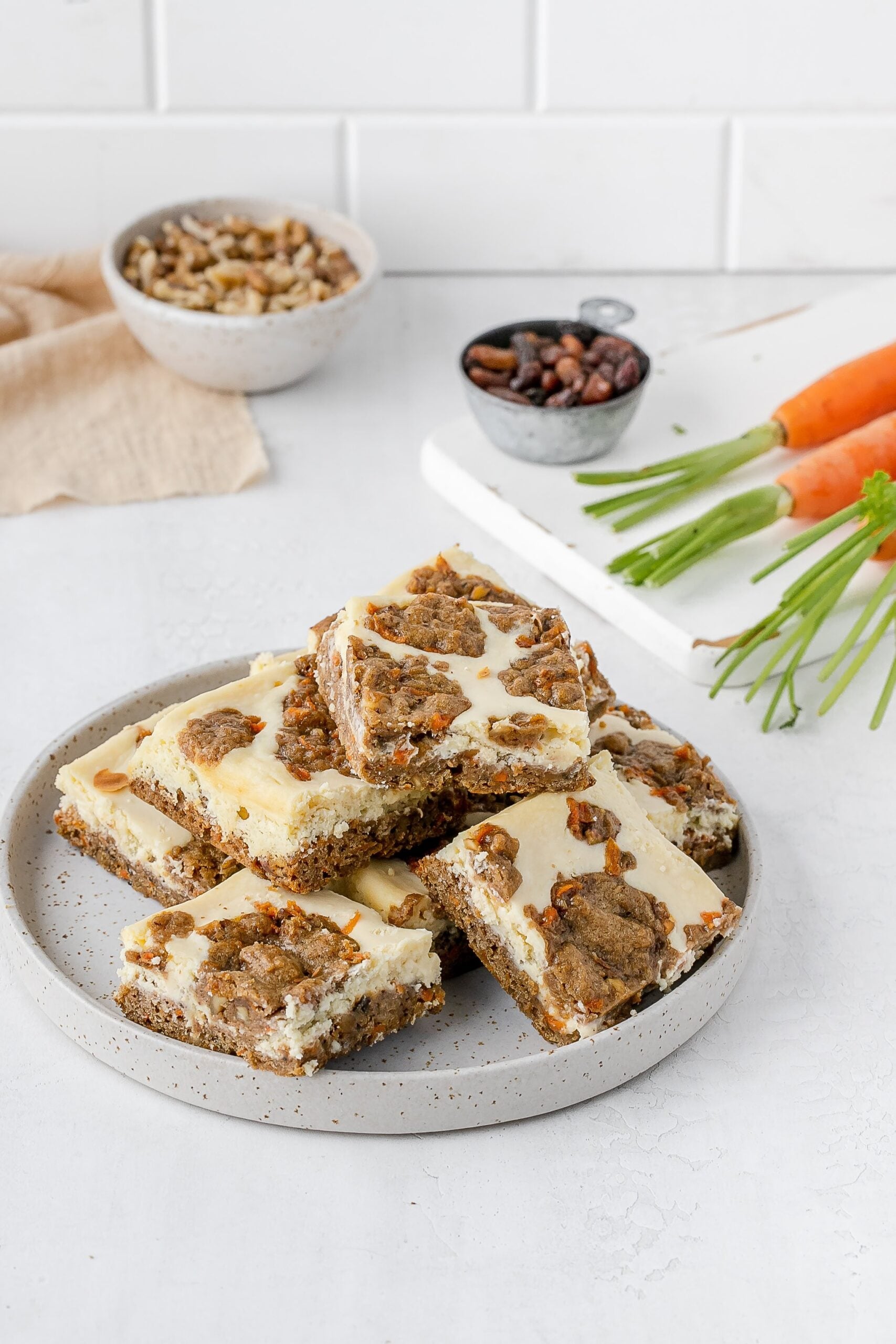 carrot cake cookie bars with cheesecake swirl on a plate.