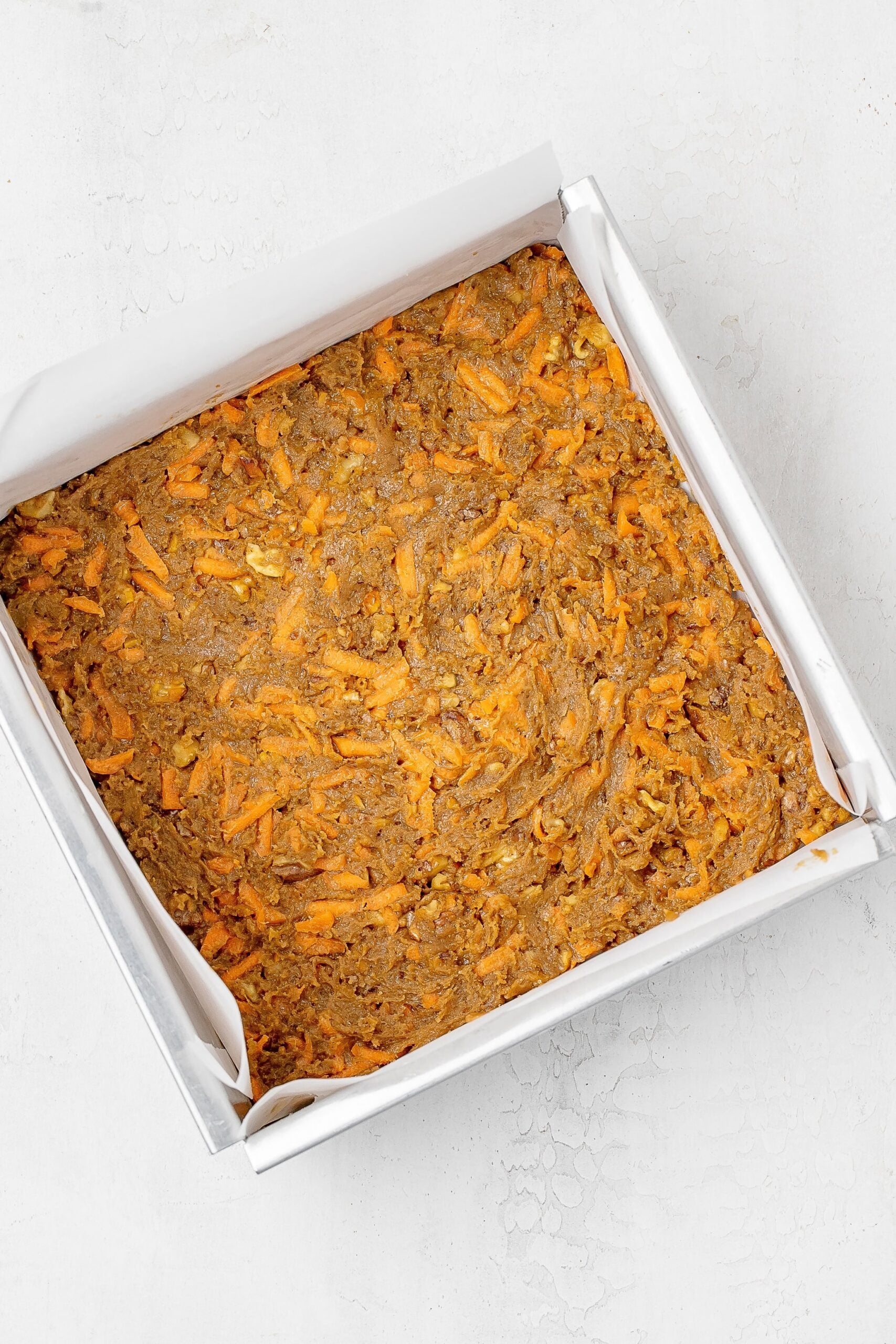 carrot cake cookie bar mixture pressed into a pan.