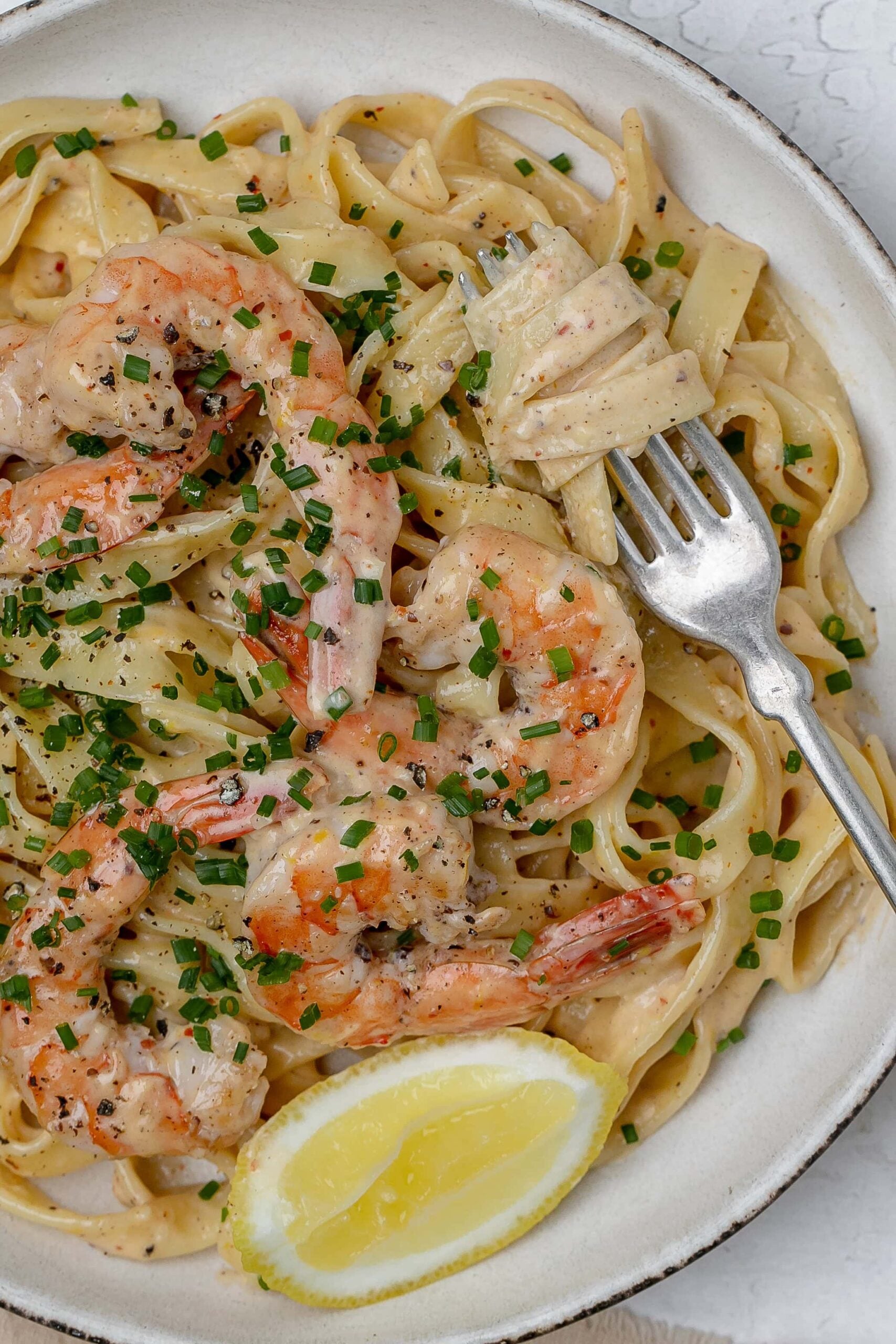 close up shot of creamy lemon pasta with shrimp on a plate. 