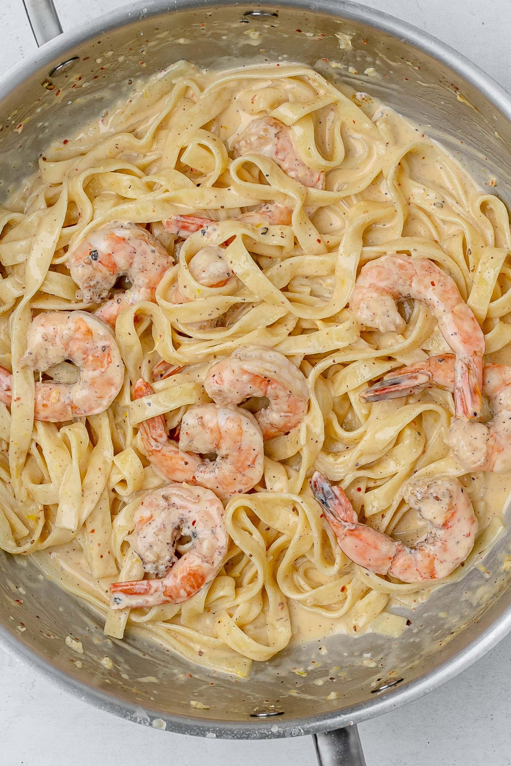 shrimp added to pasta in saucier. 