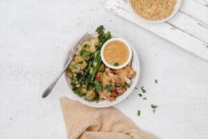miso butter chicken thighs in a bowl with rice and veggies.