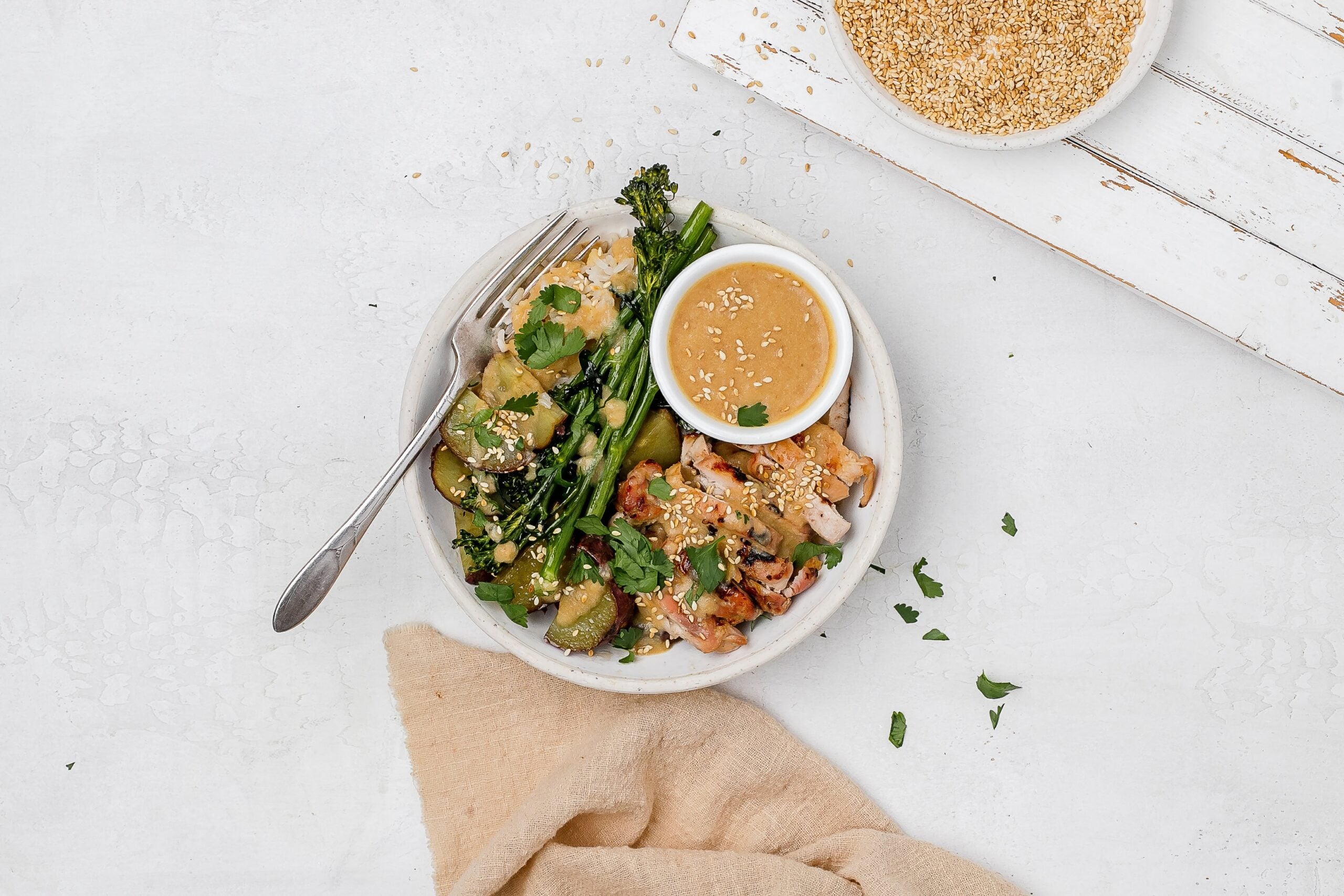 miso butter chicken thighs in a bowl with rice and veggies.