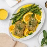 panko crusted salmon with saffron sauce on a platter with asparagus.