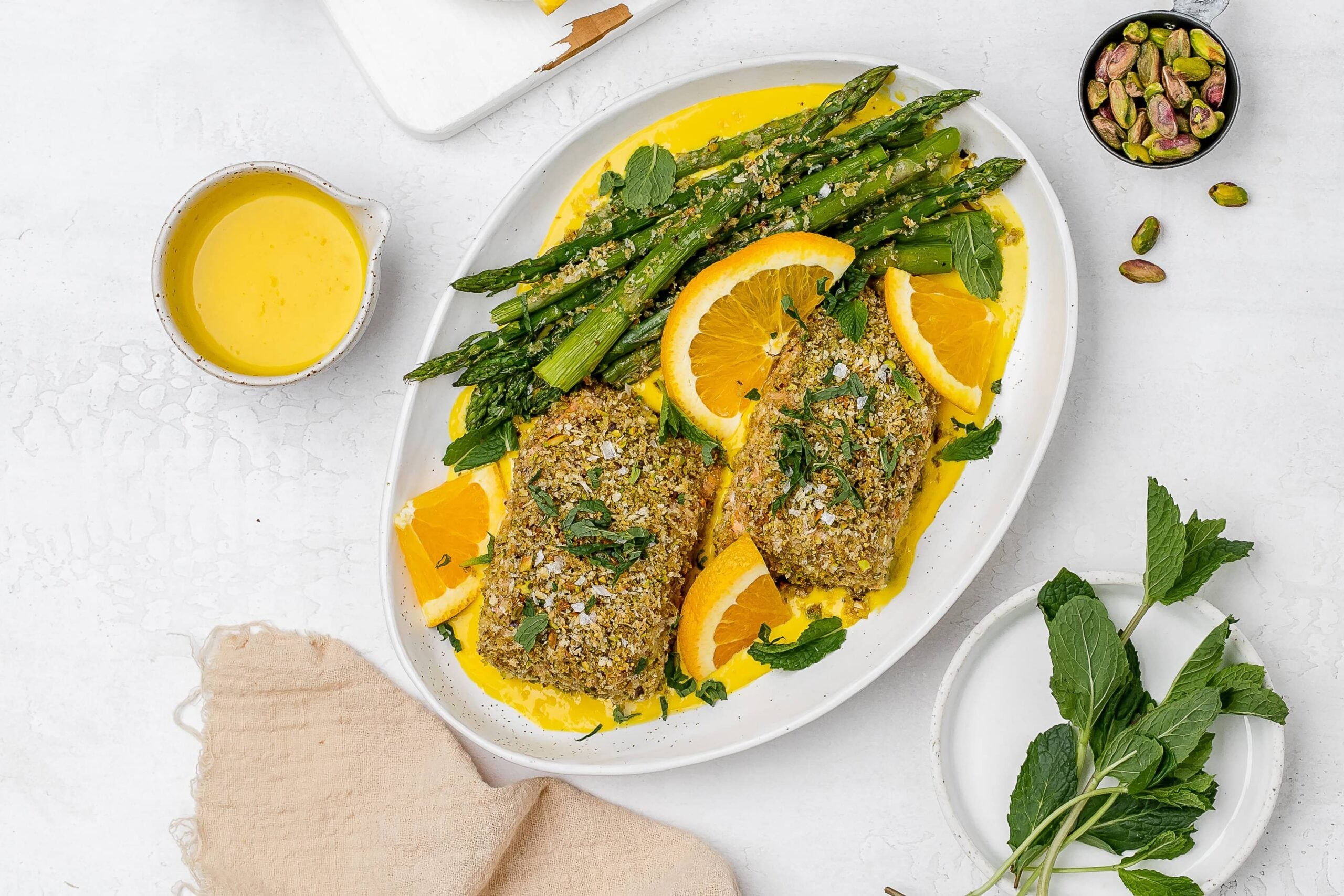 panko crusted salmon with saffron sauce on a platter with asparagus.
