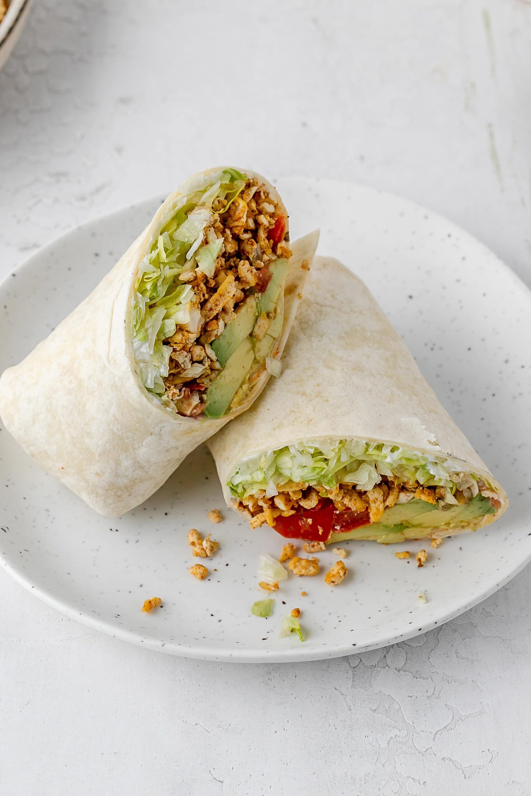 shredded taco spiced tofu wrap on a plate.
