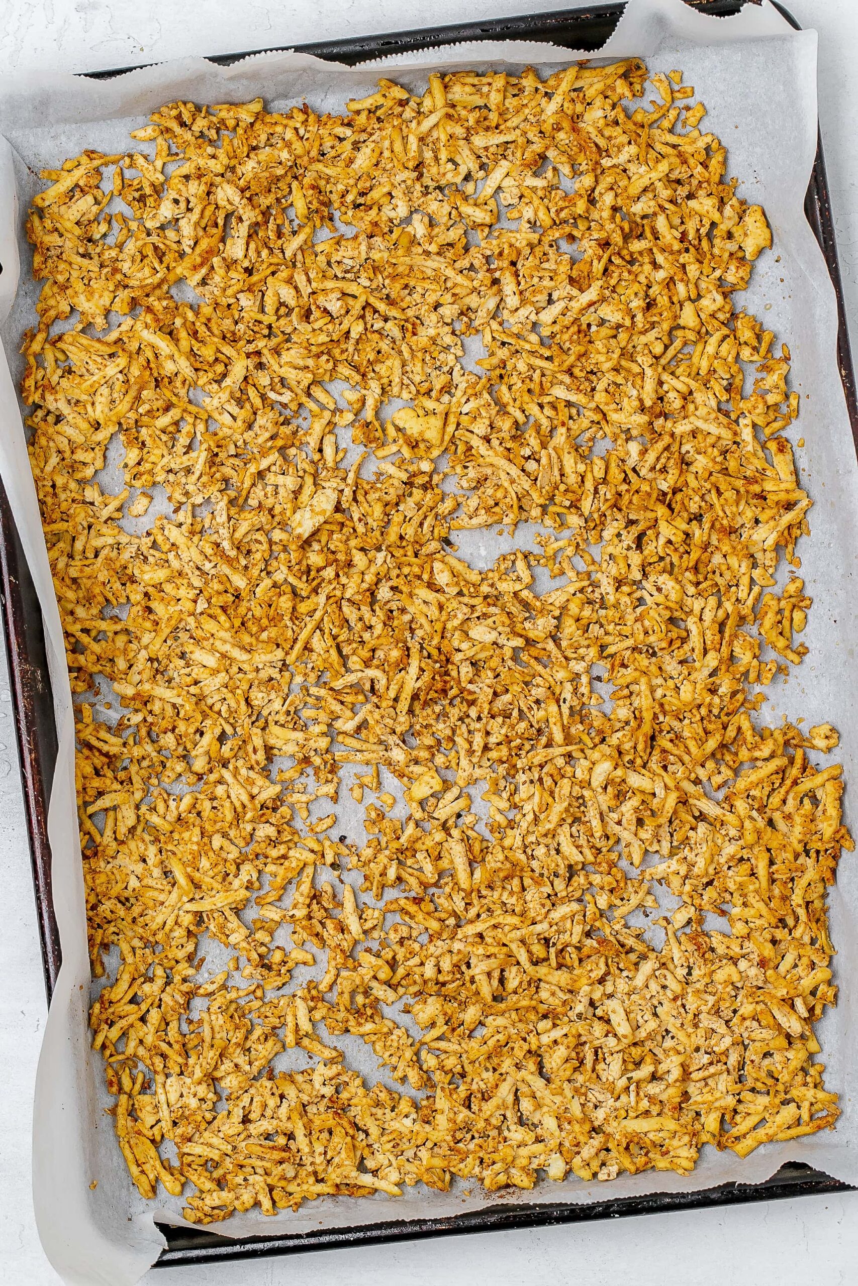 shredded tofu on baking sheet after cooking. 