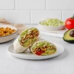 shredded taco spiced tofu wrap on a plate.