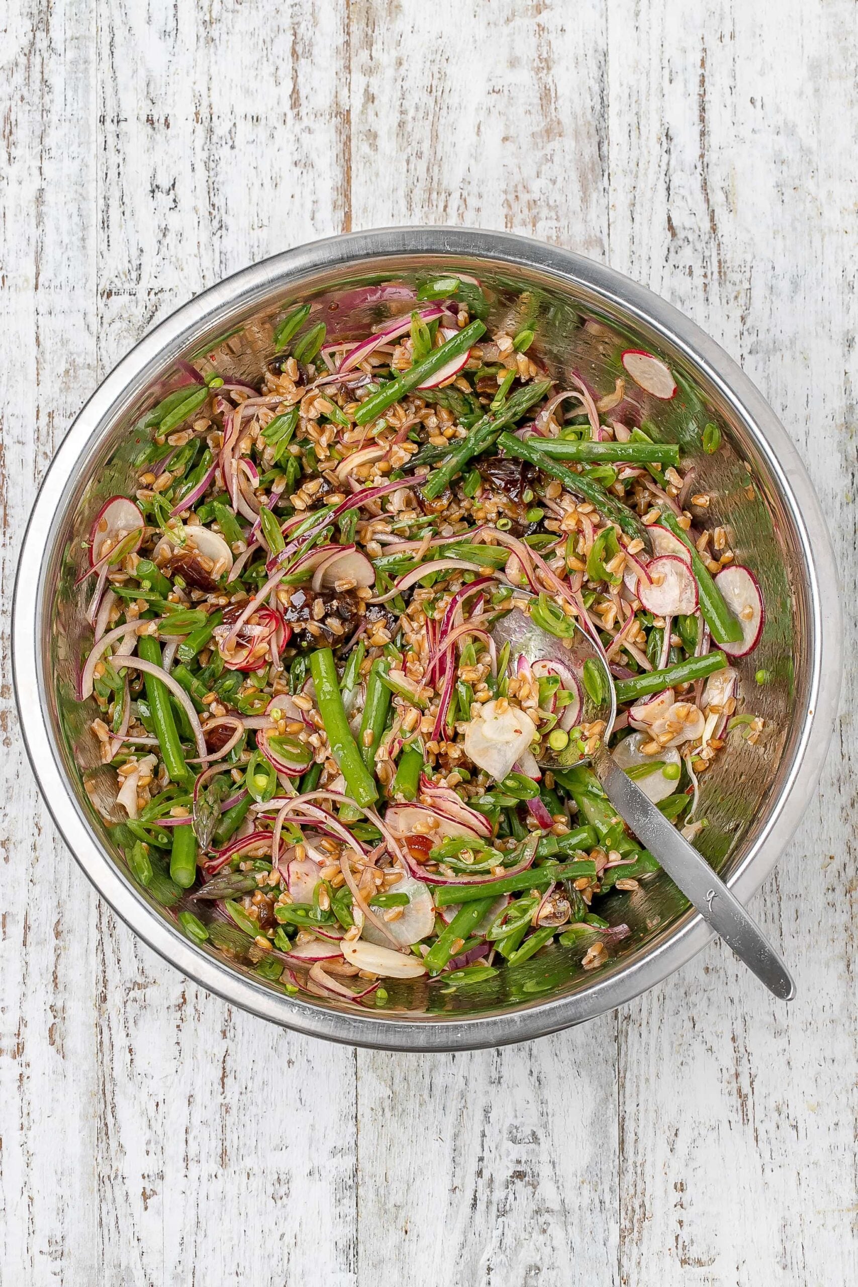 farro salad in a large bowl tossed with dressing. 