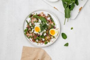 asparagus farro salad on a plate with a jammy egg.