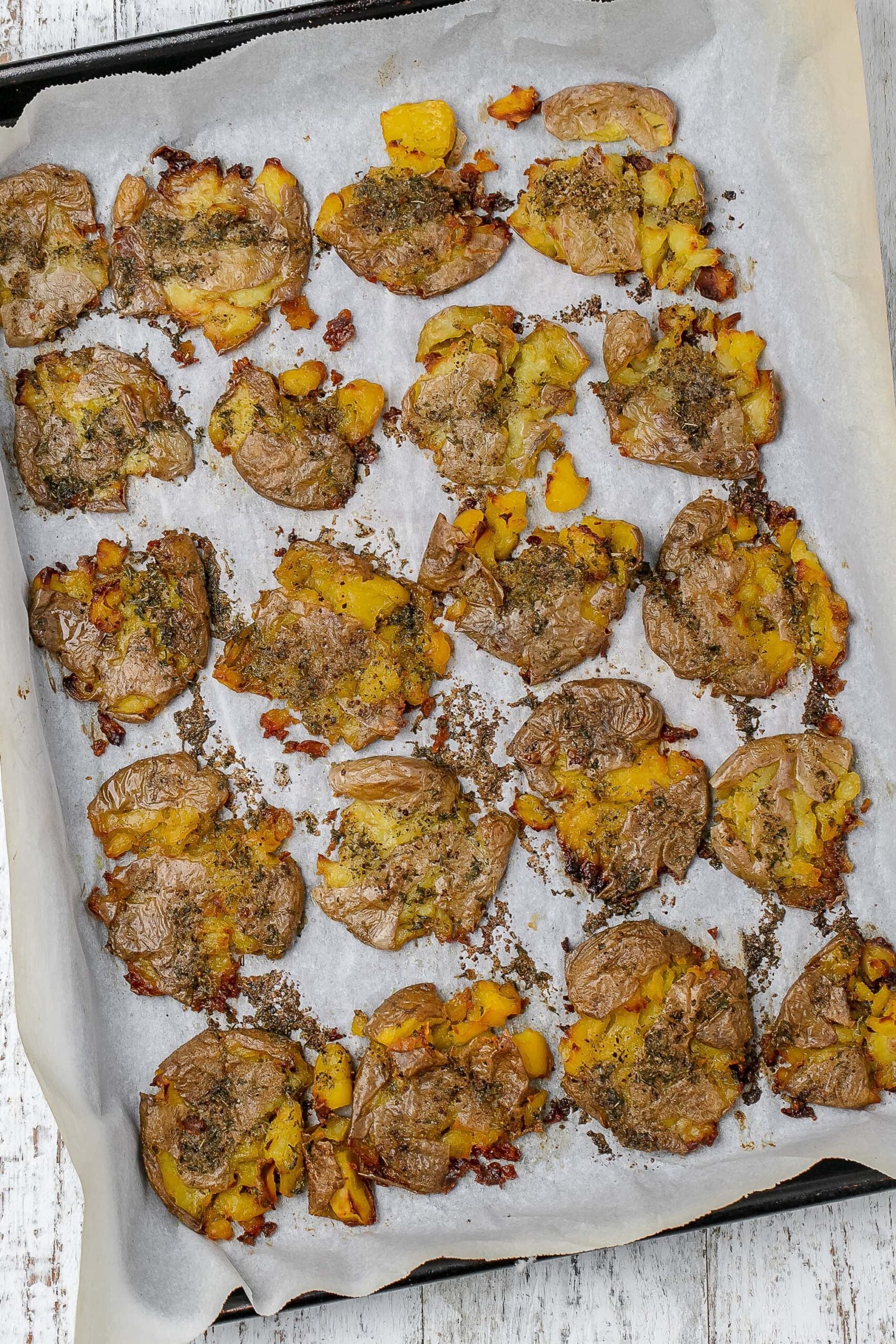 Greek smashed potatoes on a baking sheet.