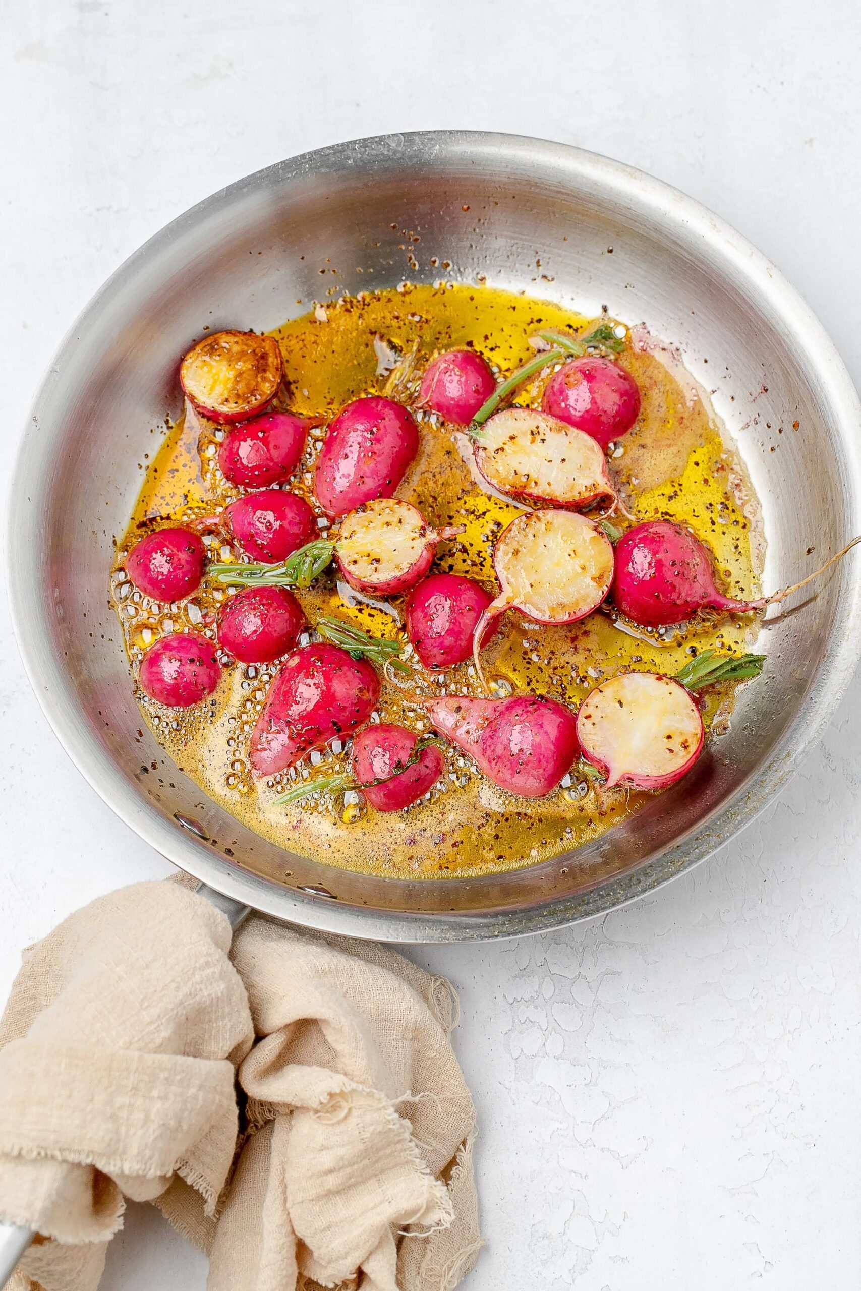 radishes being sautéed in a skillet with butter.