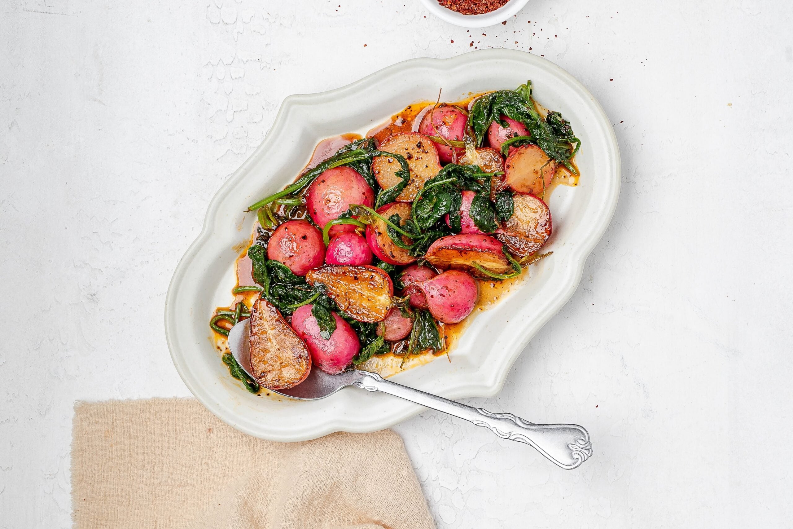 sautéed radishes on a platter with butter sauce.