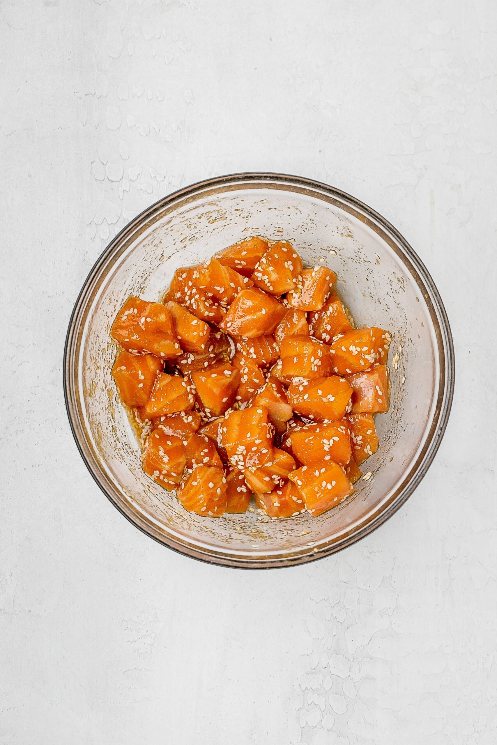 cubed salmon in a bowl with spices. 
