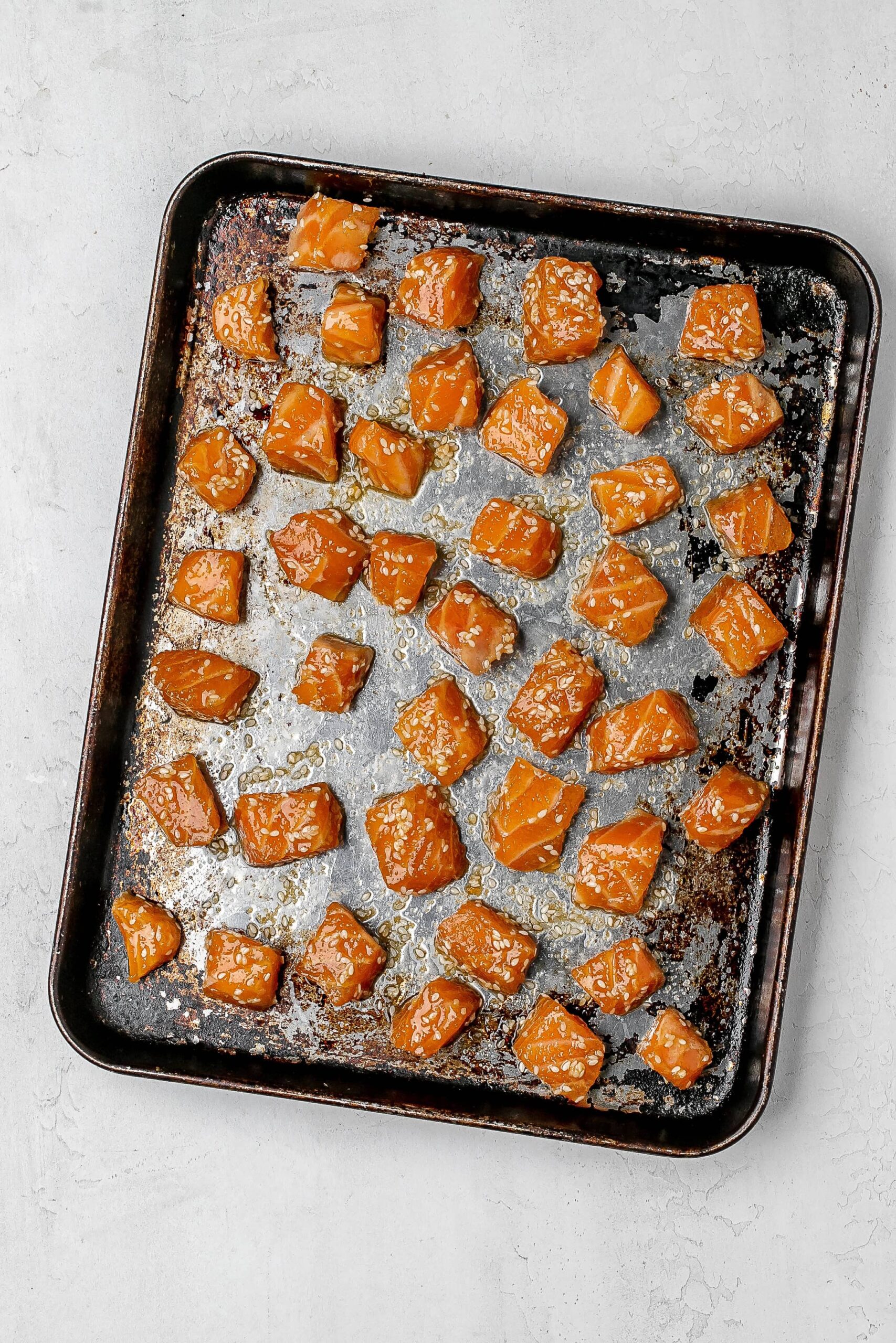 cubed salmon on a baking sheet before cooking. 