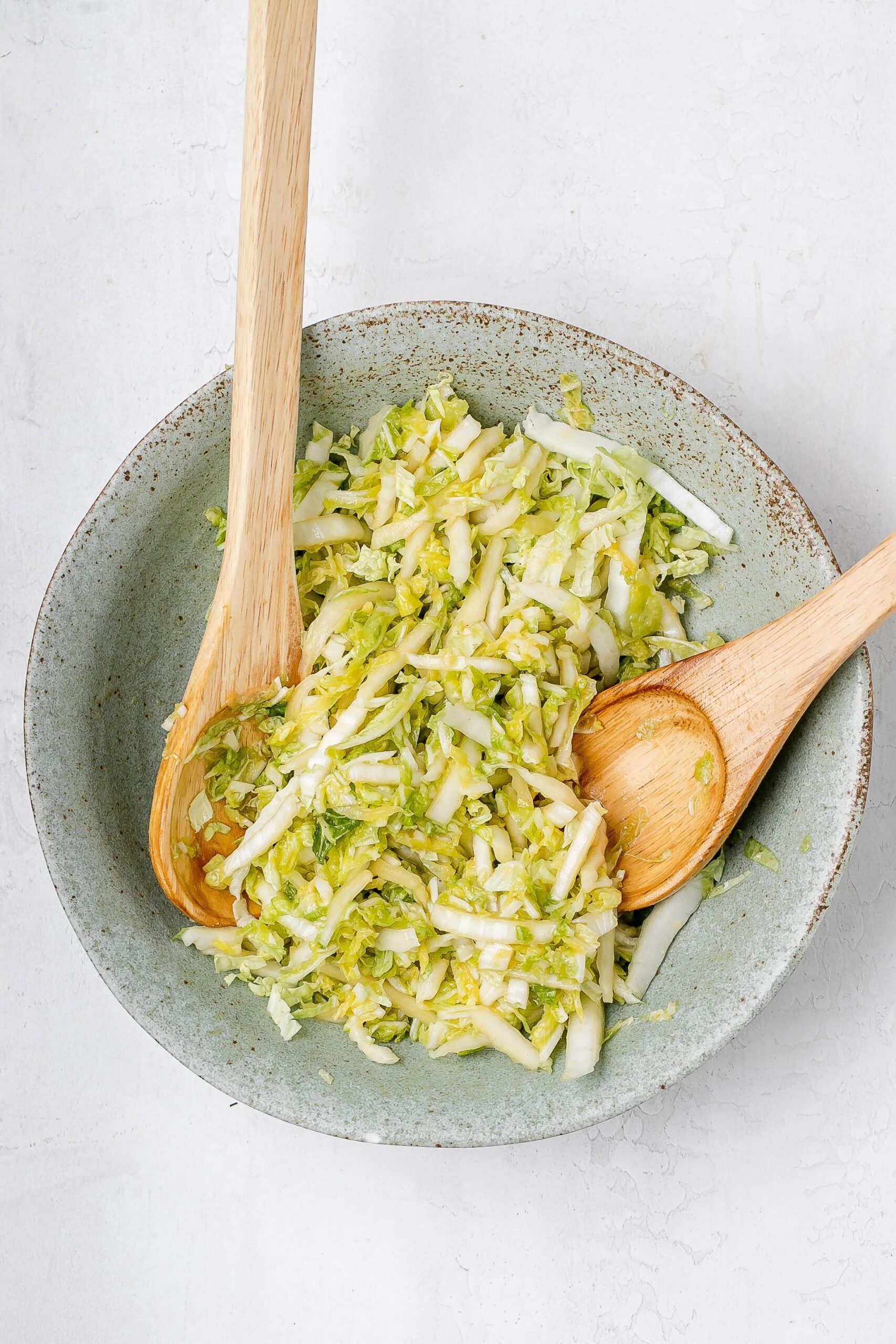 cabbage in a large bowl with dressing. 