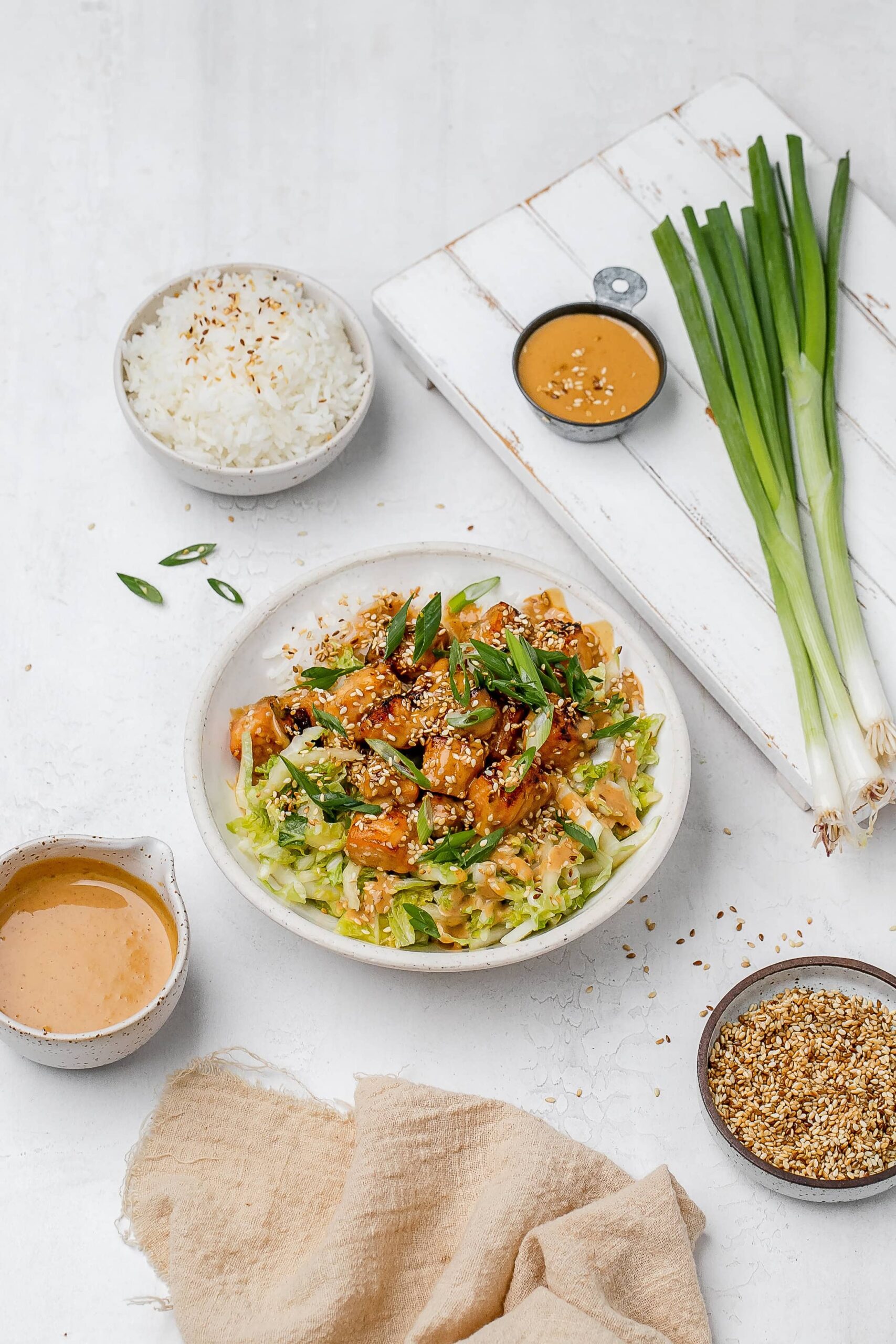 salmon with peanut sauce in a bowl with rice and cabbage slaw.