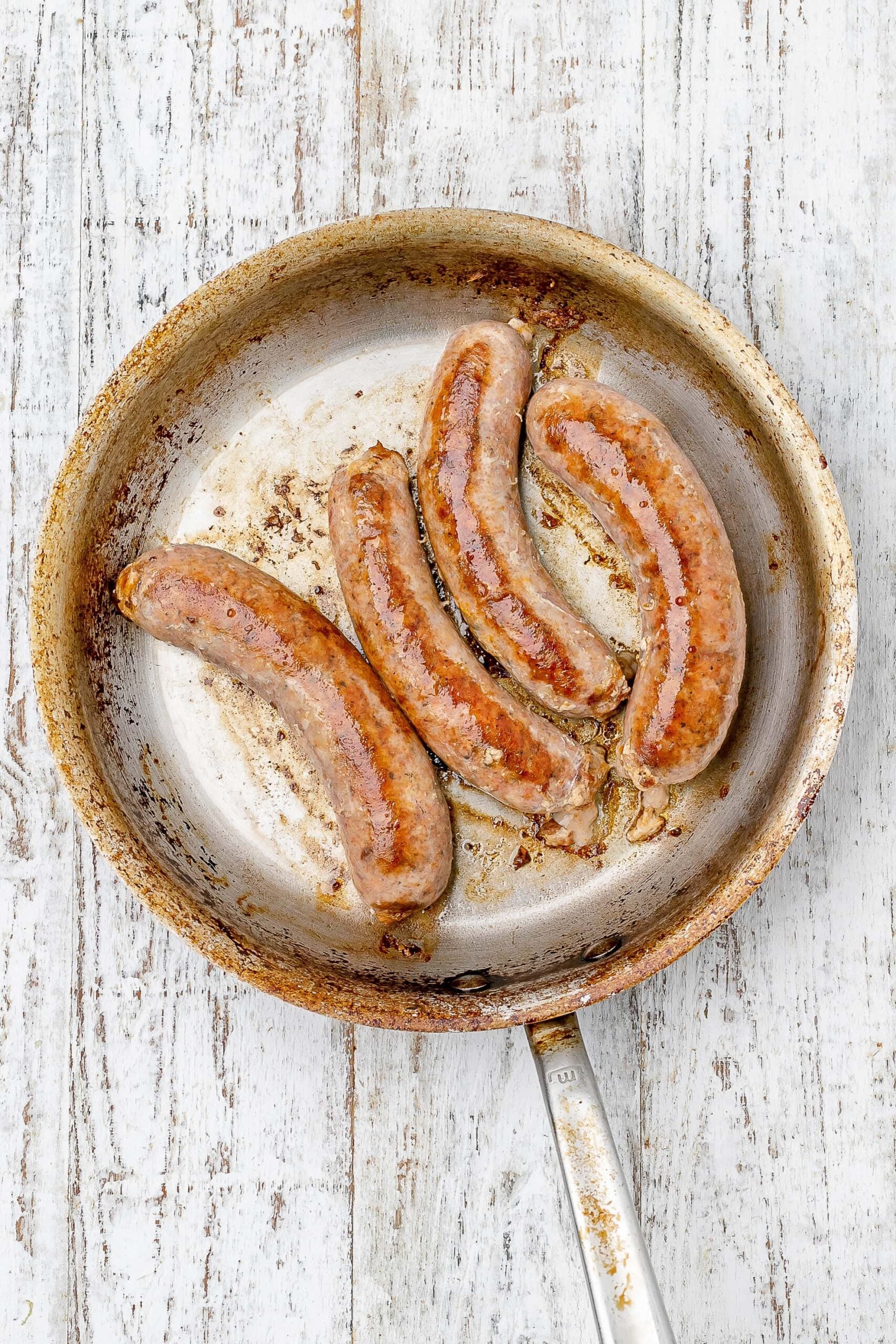 sausages seared in a skillet.