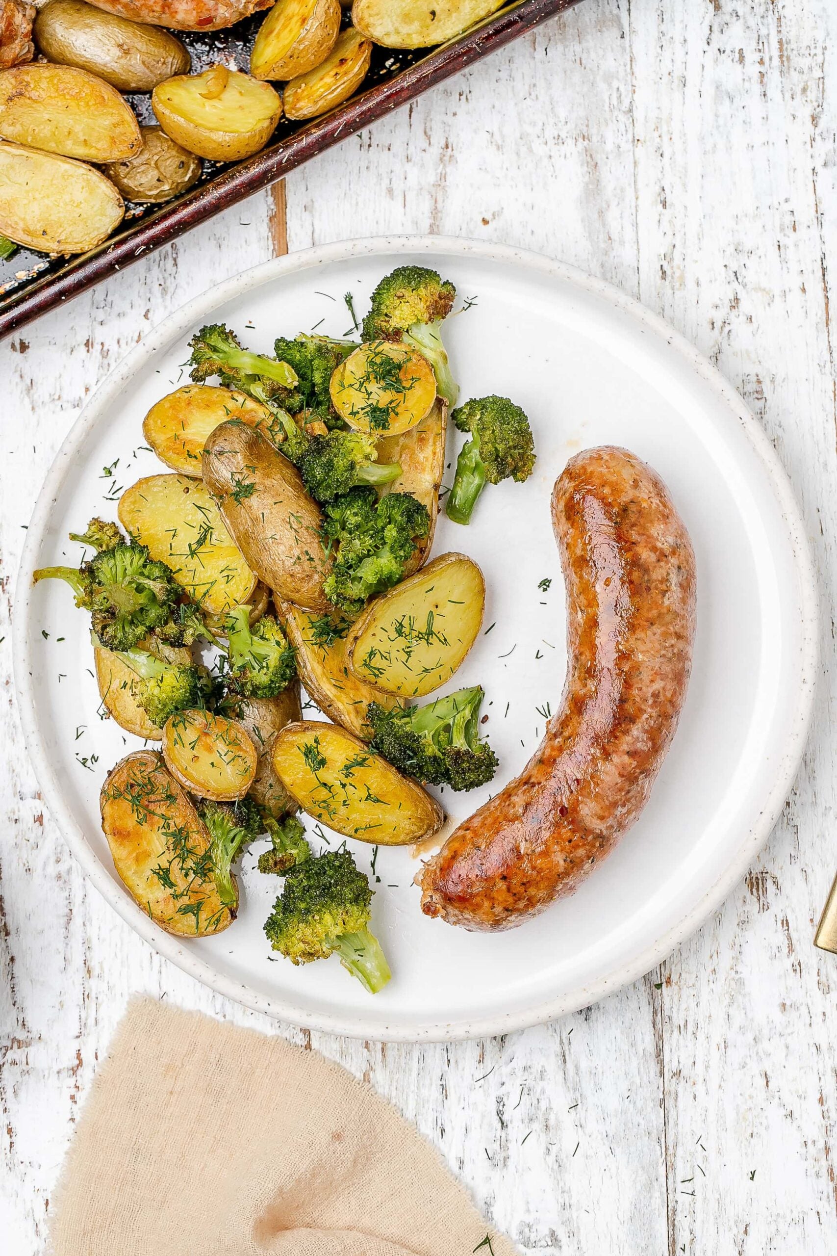 sausage, potato and broccoli on a plate.