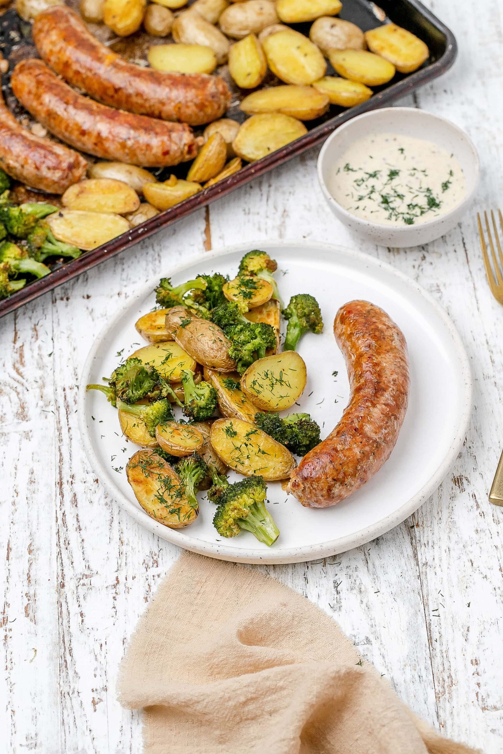 sausage, potato and broccoli on a plate.