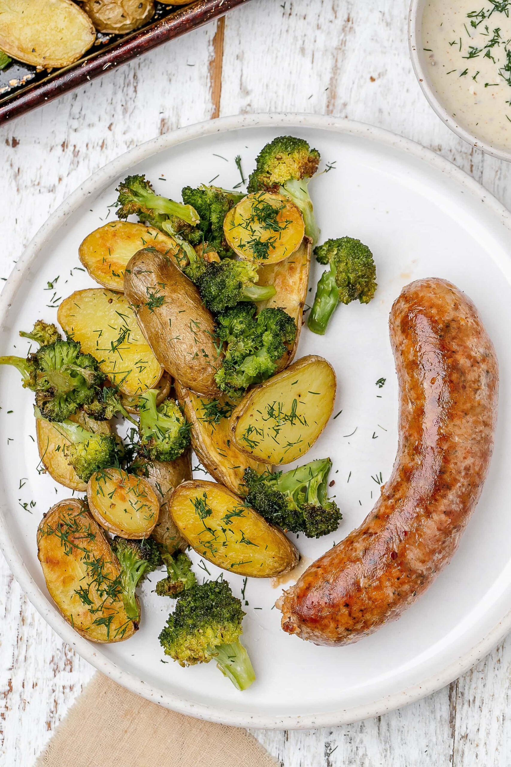sausage, potato and broccoli on a plate.