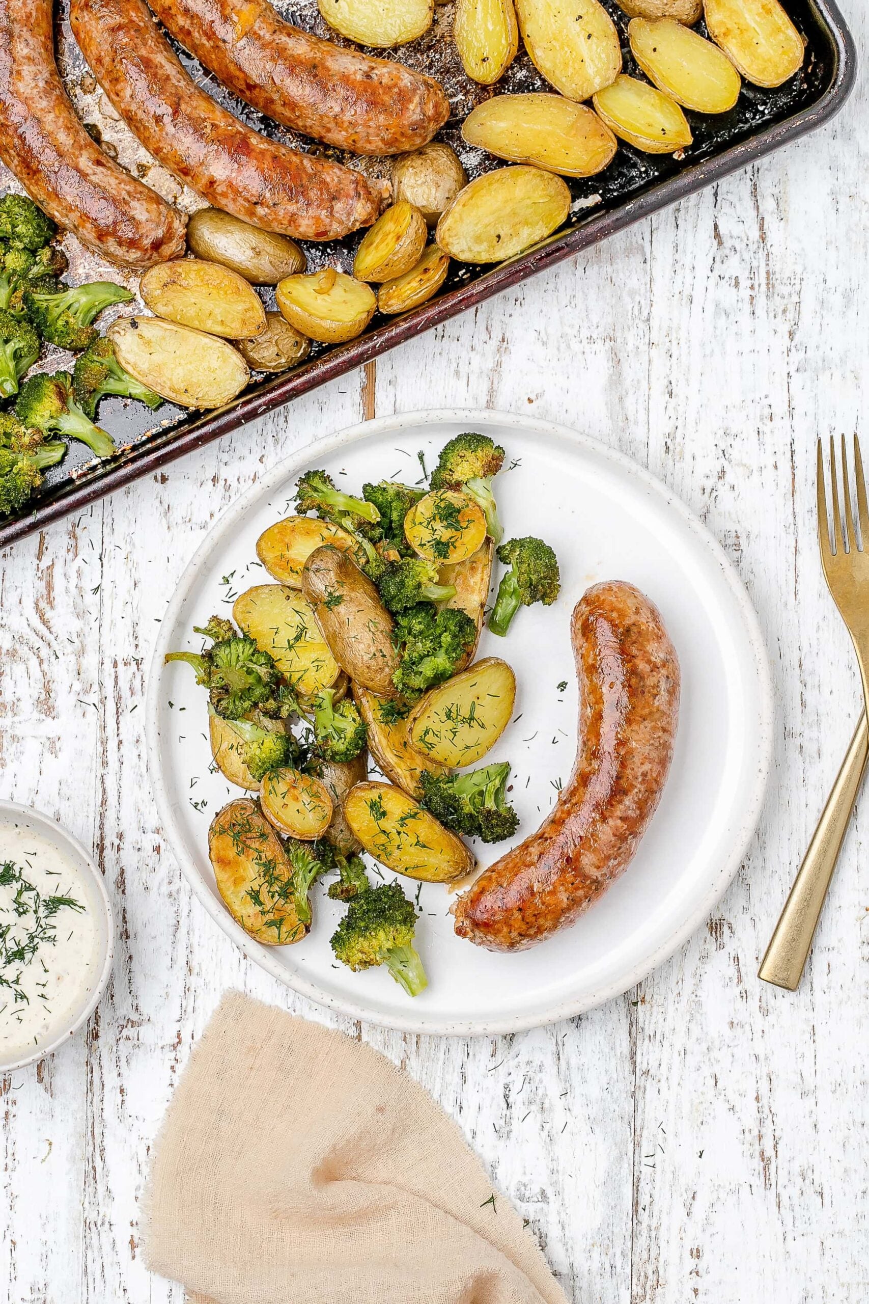 sausage, potato and broccoli on a plate.