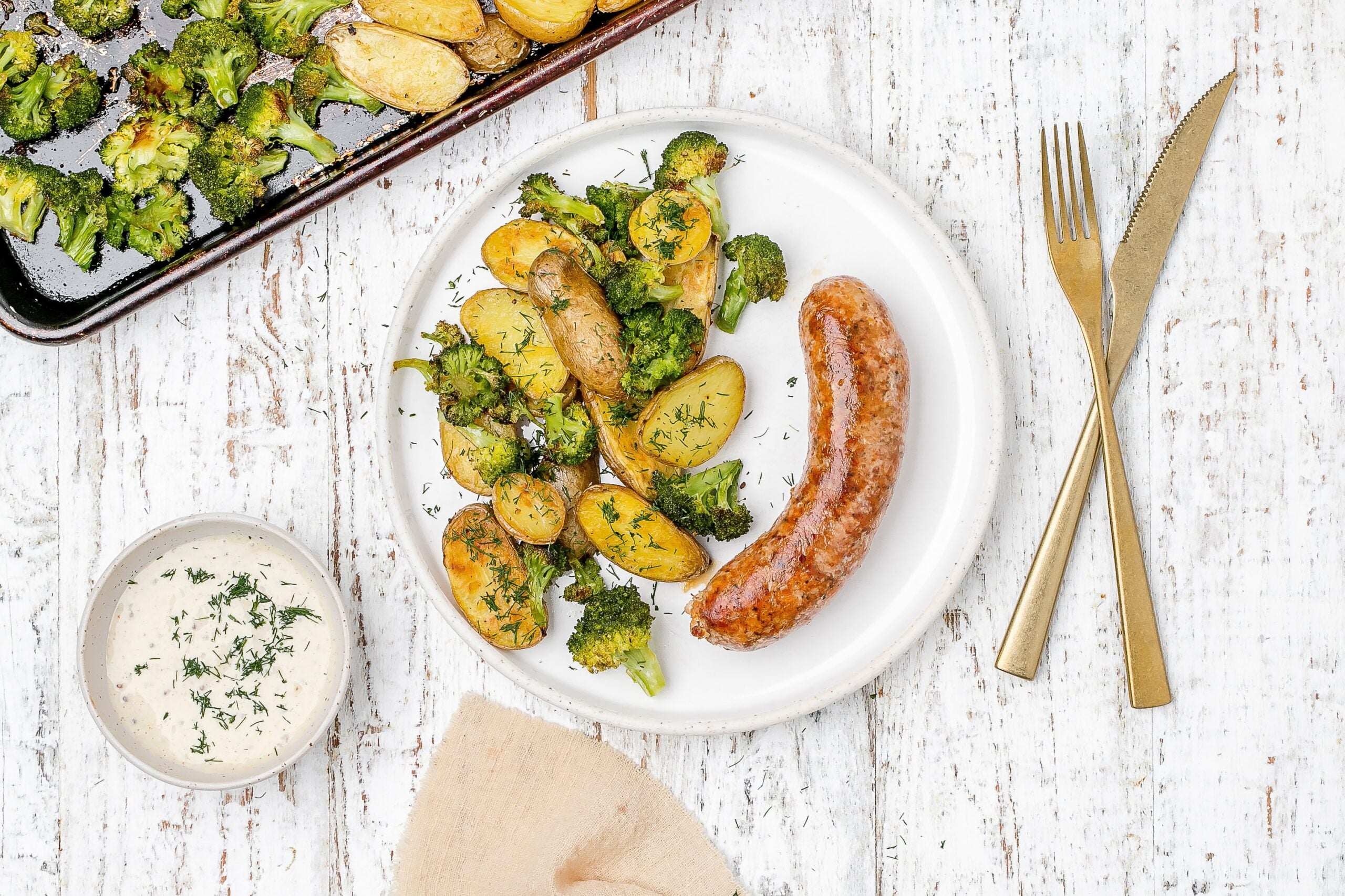 sausage, potato and broccoli on a plate.