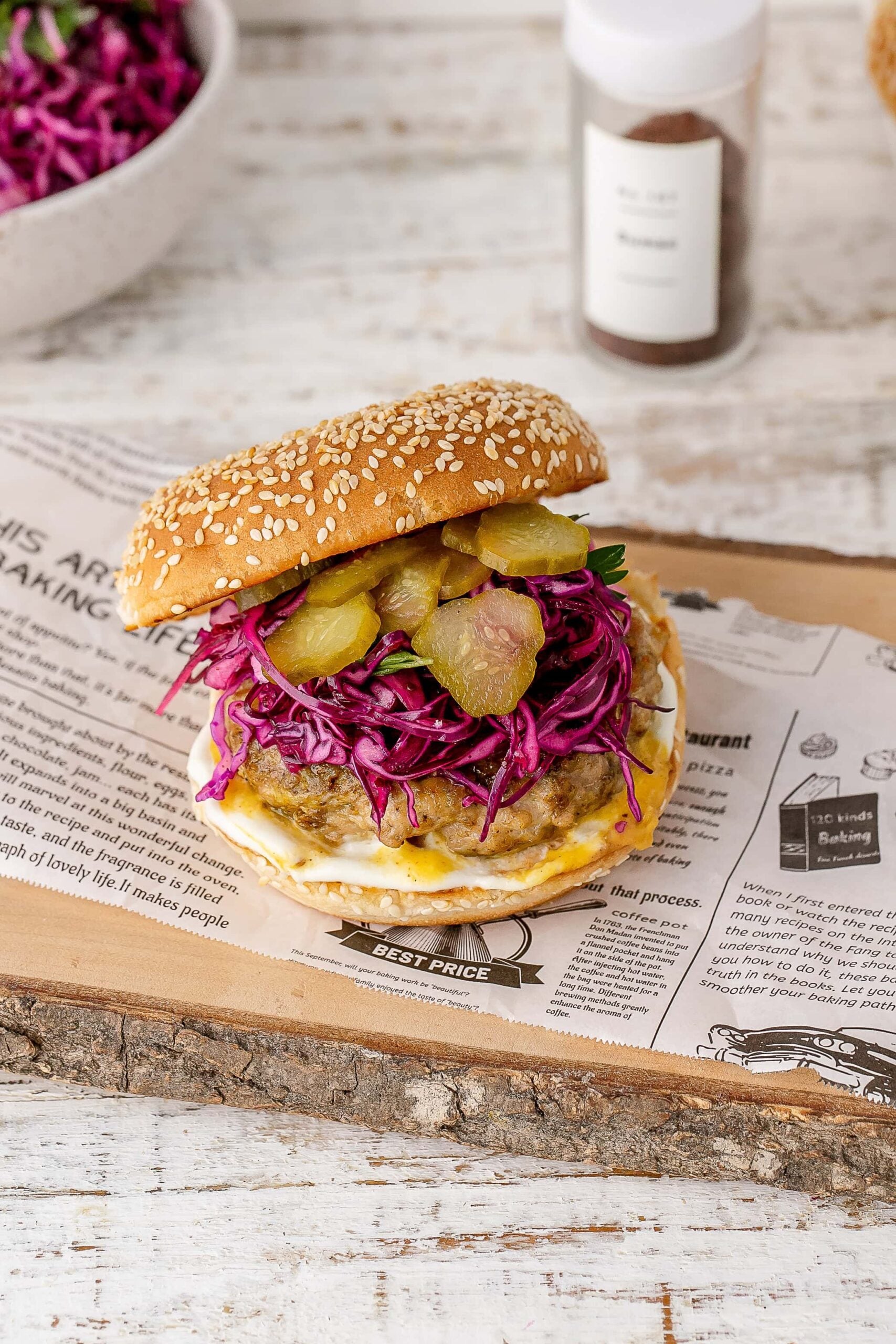 chicken shawarma burger with a bun and slaw on a plate. 