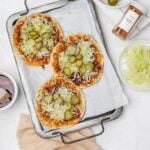 smashed Nashville hot chicken tacos on a baking sheet with toppings.