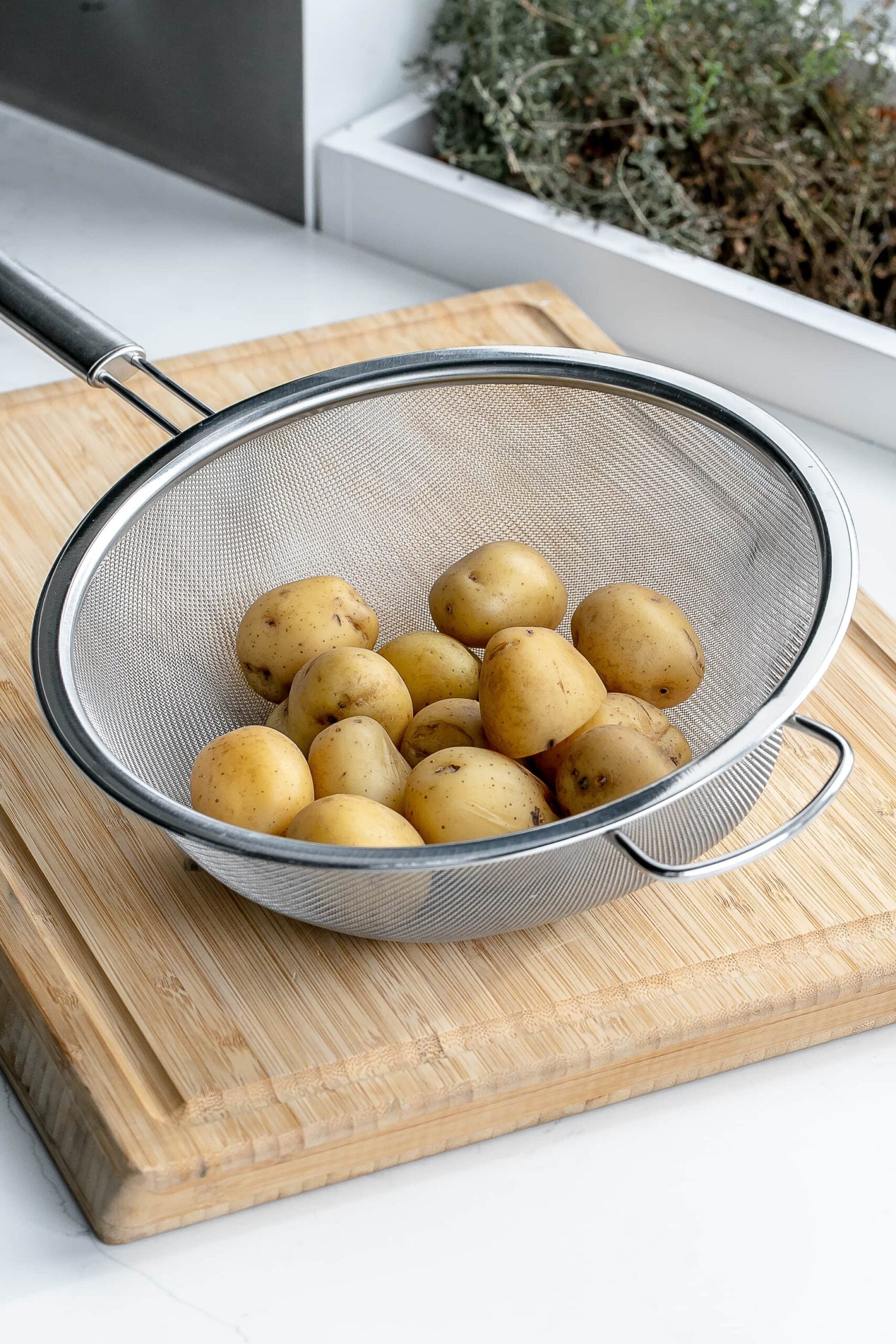 boiled potatoes in a sieve.